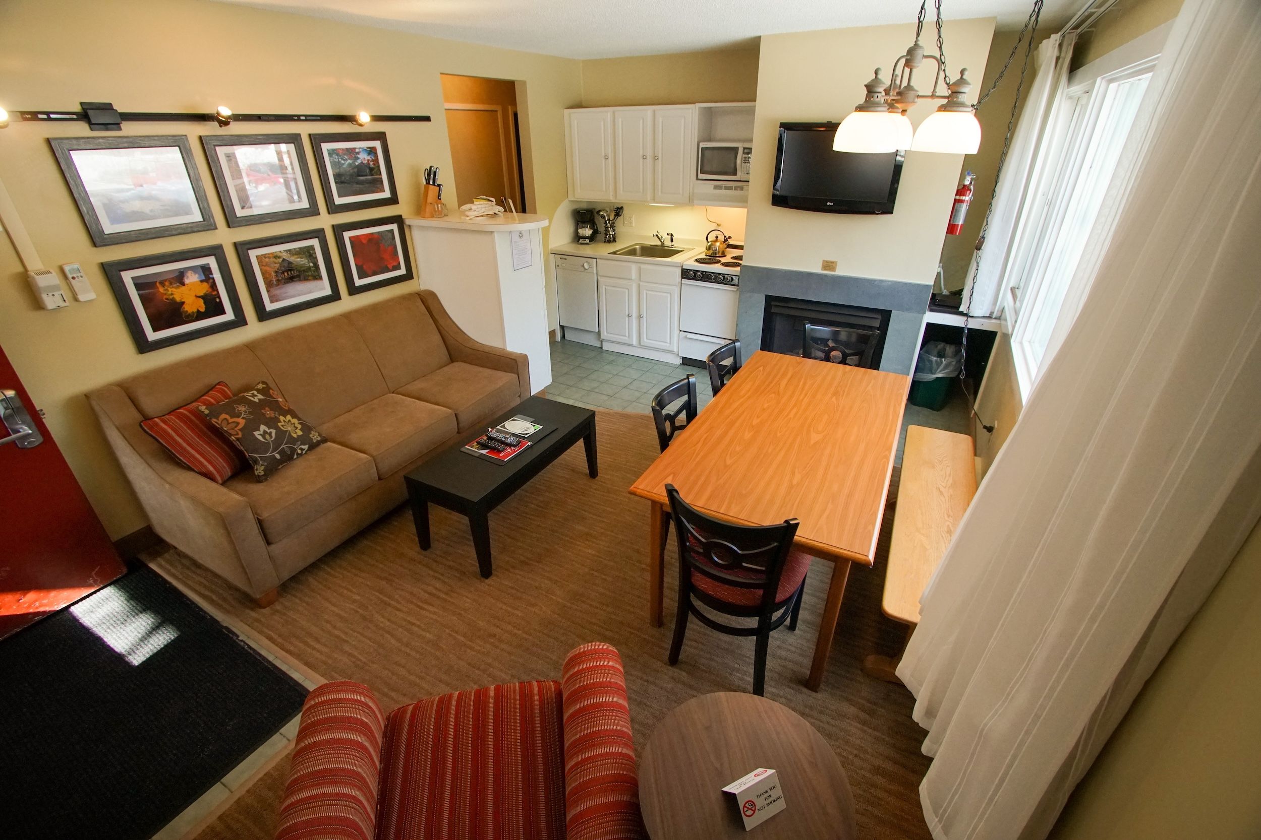 image Gather around the fireplace, where warmth meets comfort in an inviting living and dining space.