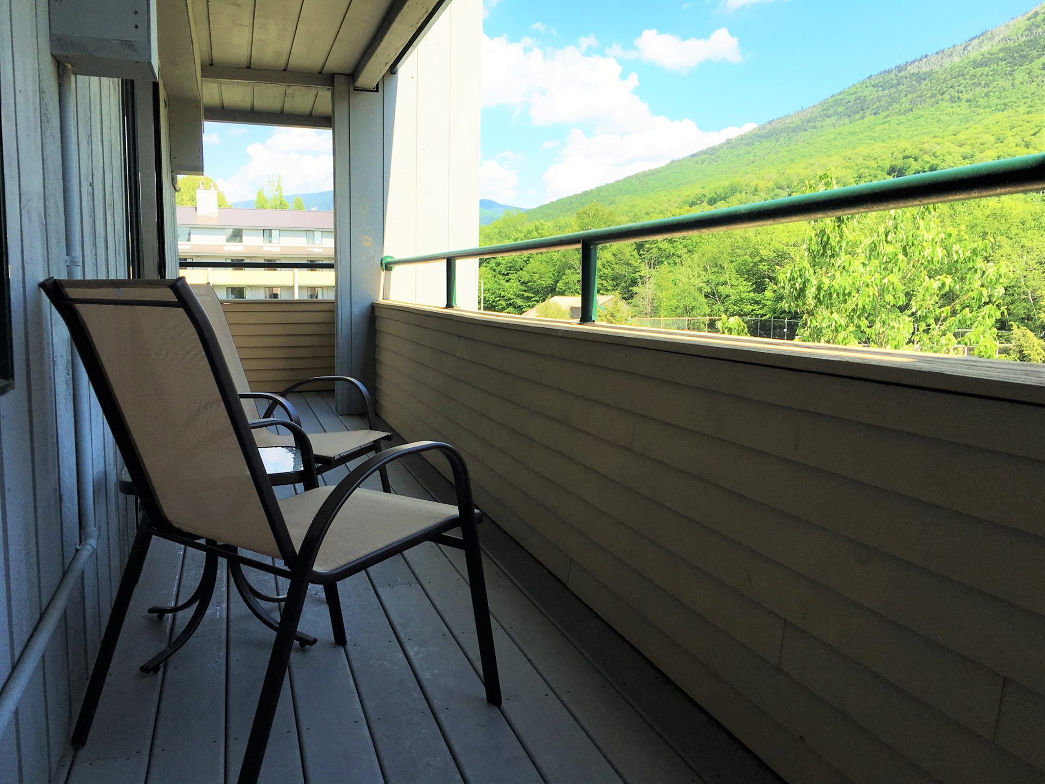 image Experience serene moments on the spacious private balcony, overlooking the lush landscape of the White Mountains.