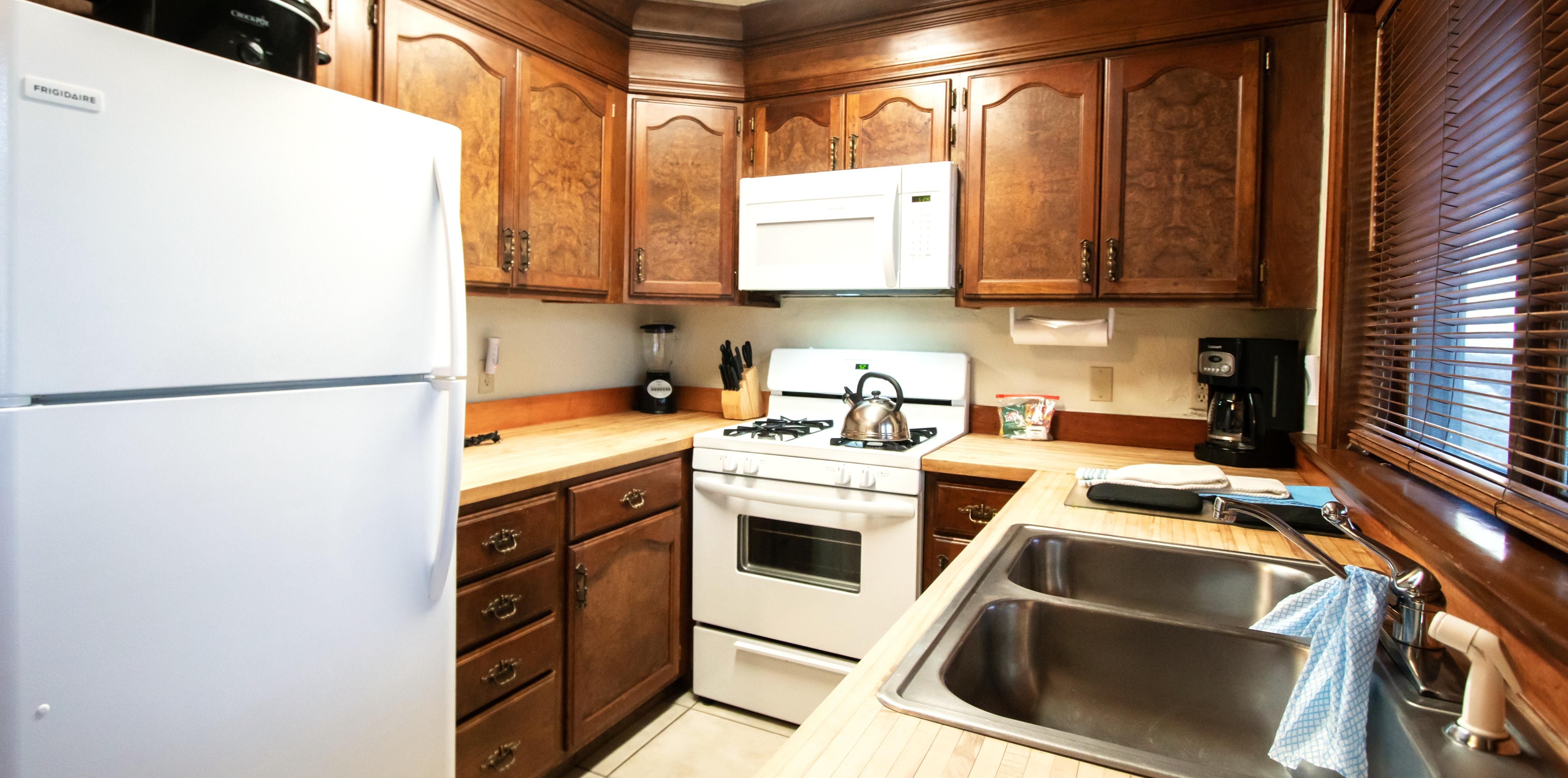 image A fully equipped kitchen with rich wooden cabinets and modern appliances, perfect for preparing meals.