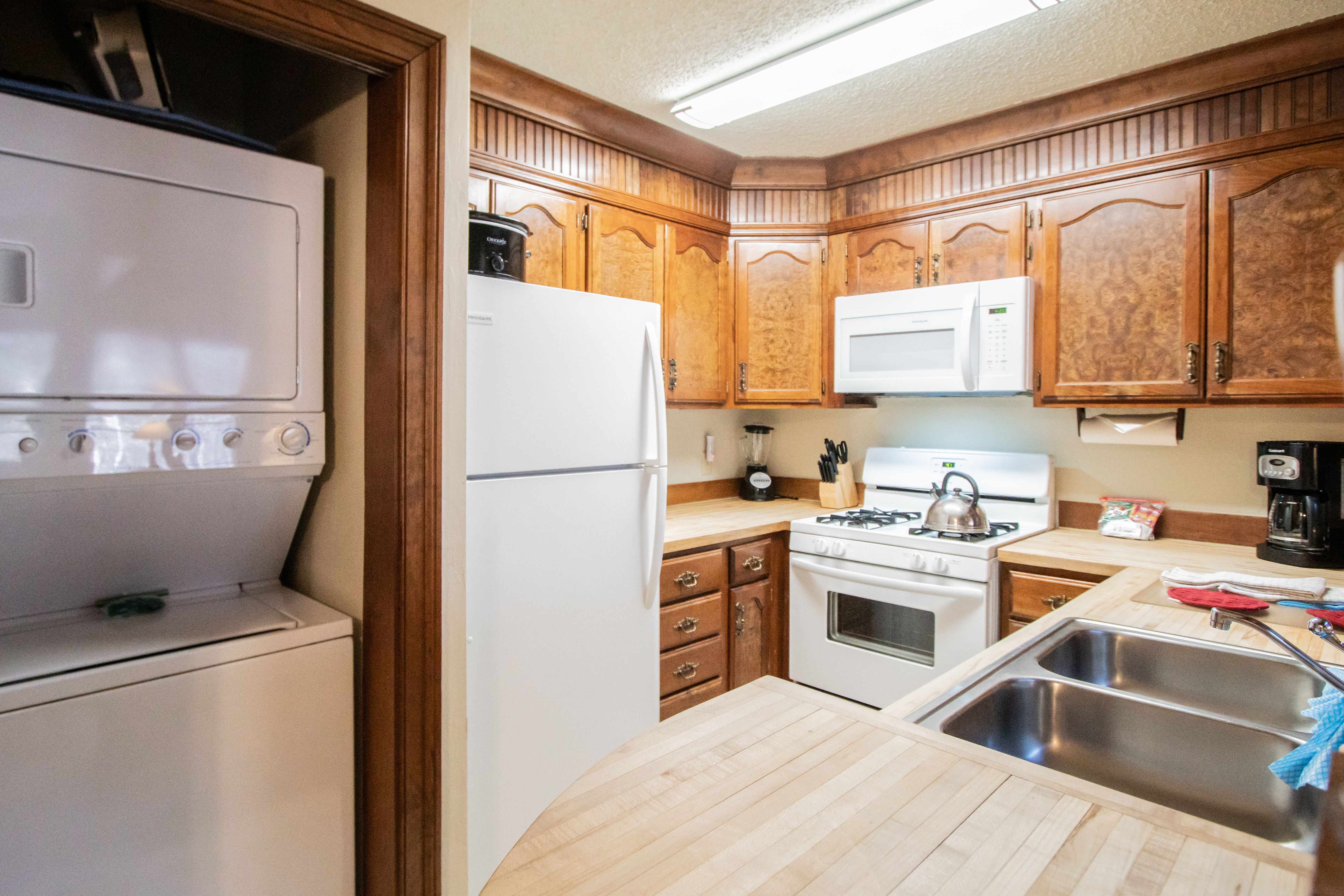 image The full kitchen boasts traditional wooden cabinetry and modern appliances, making it easy to prepare delicious meals at home.