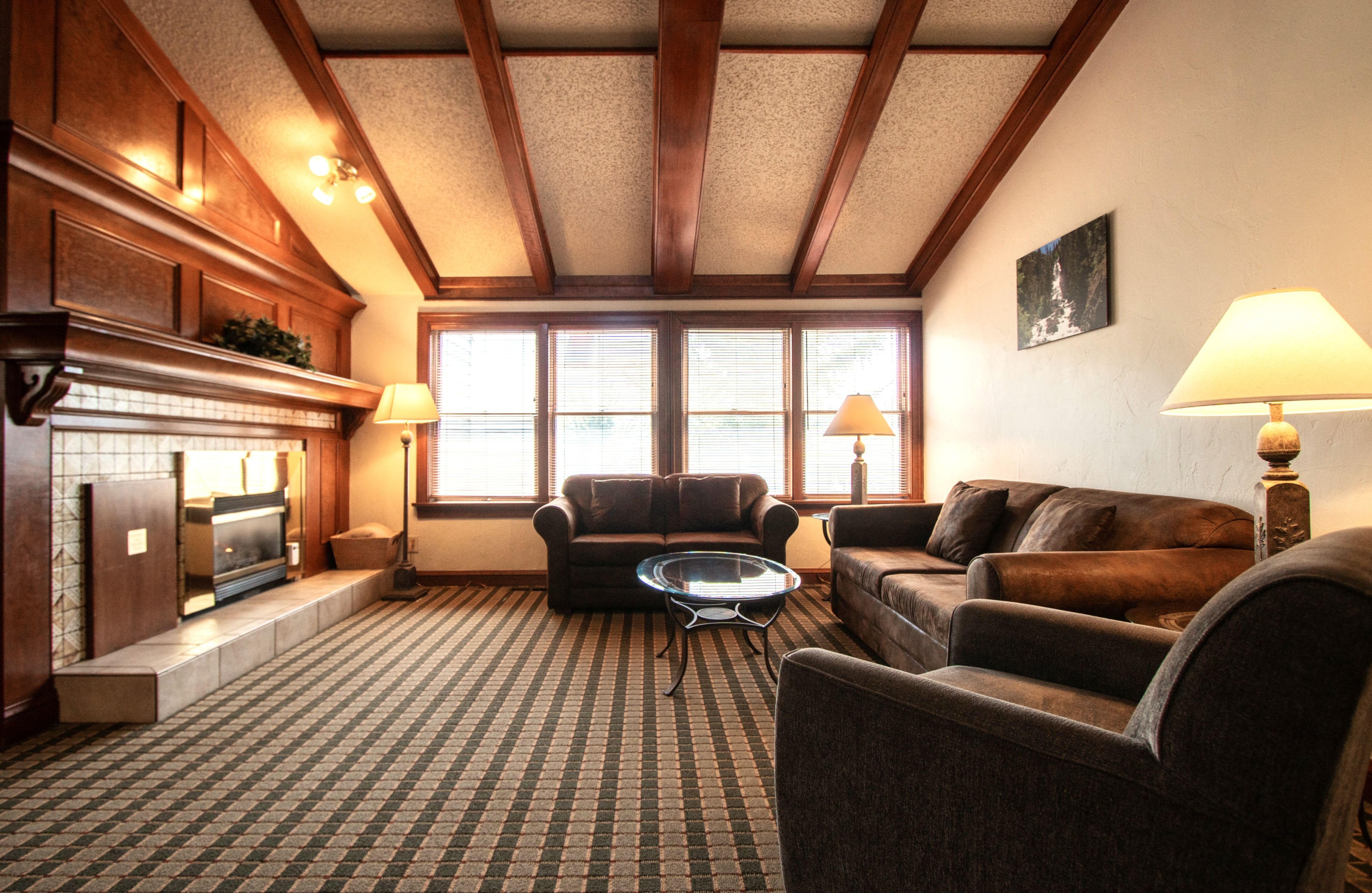 image This inviting living space offers a cozy gathering area with a fireplace and large windows showcasing stunning mountain views.