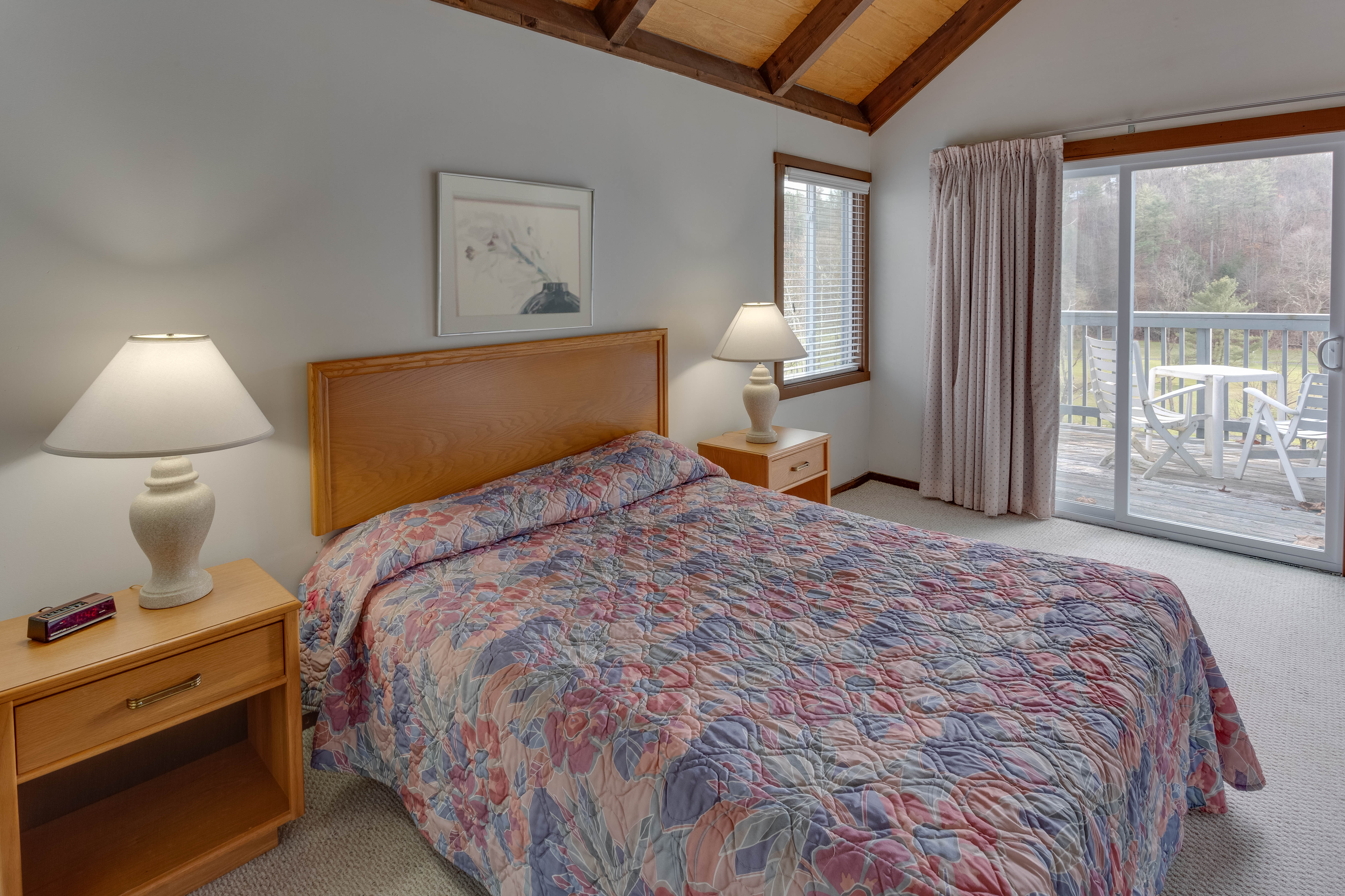 image Comfortable queen bedroom on the main floor with wooded views and easy access to both bathrooms.