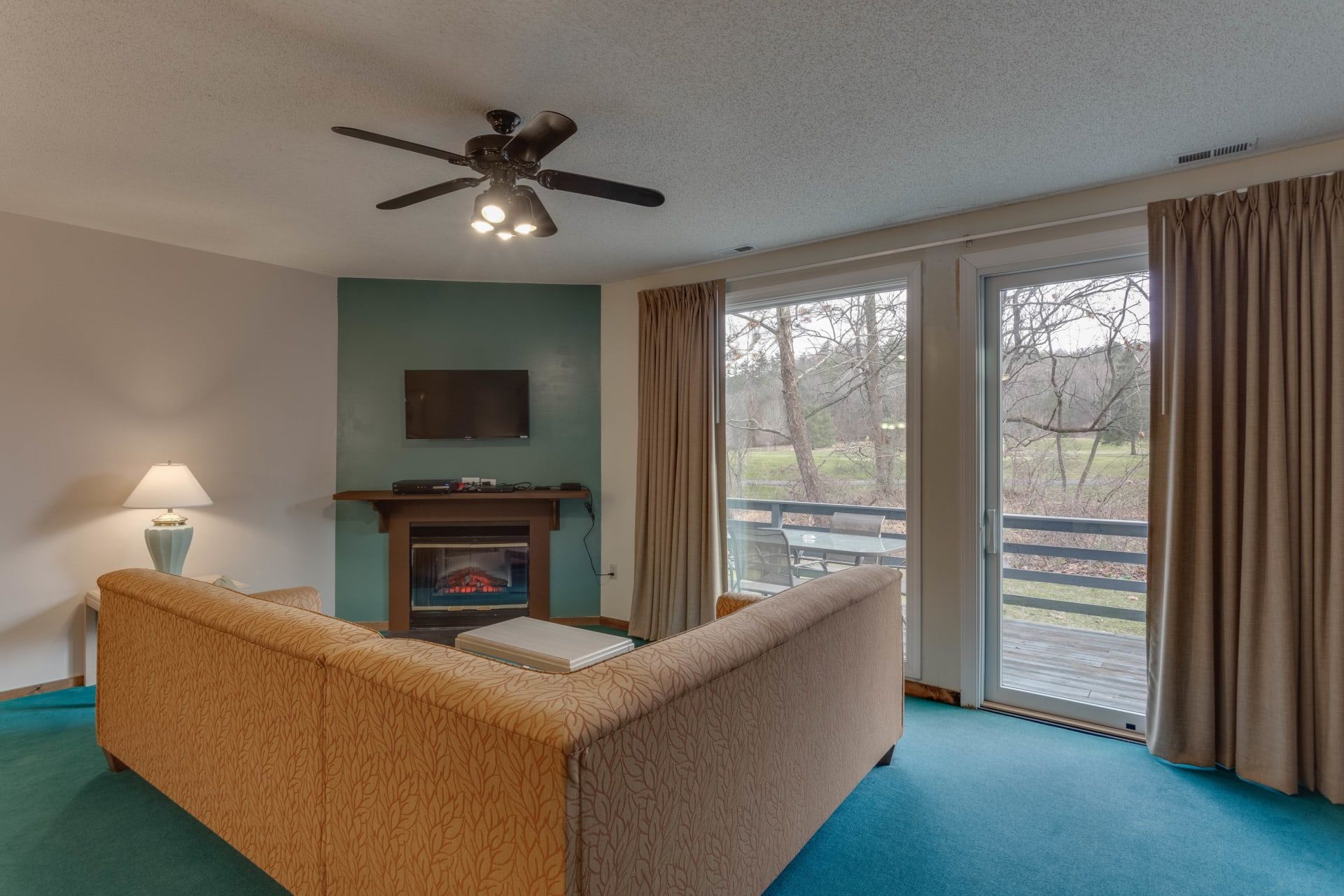 image Bright and cozy living area featuring a sleeper sofa and electric fireplace for ultimate comfort.