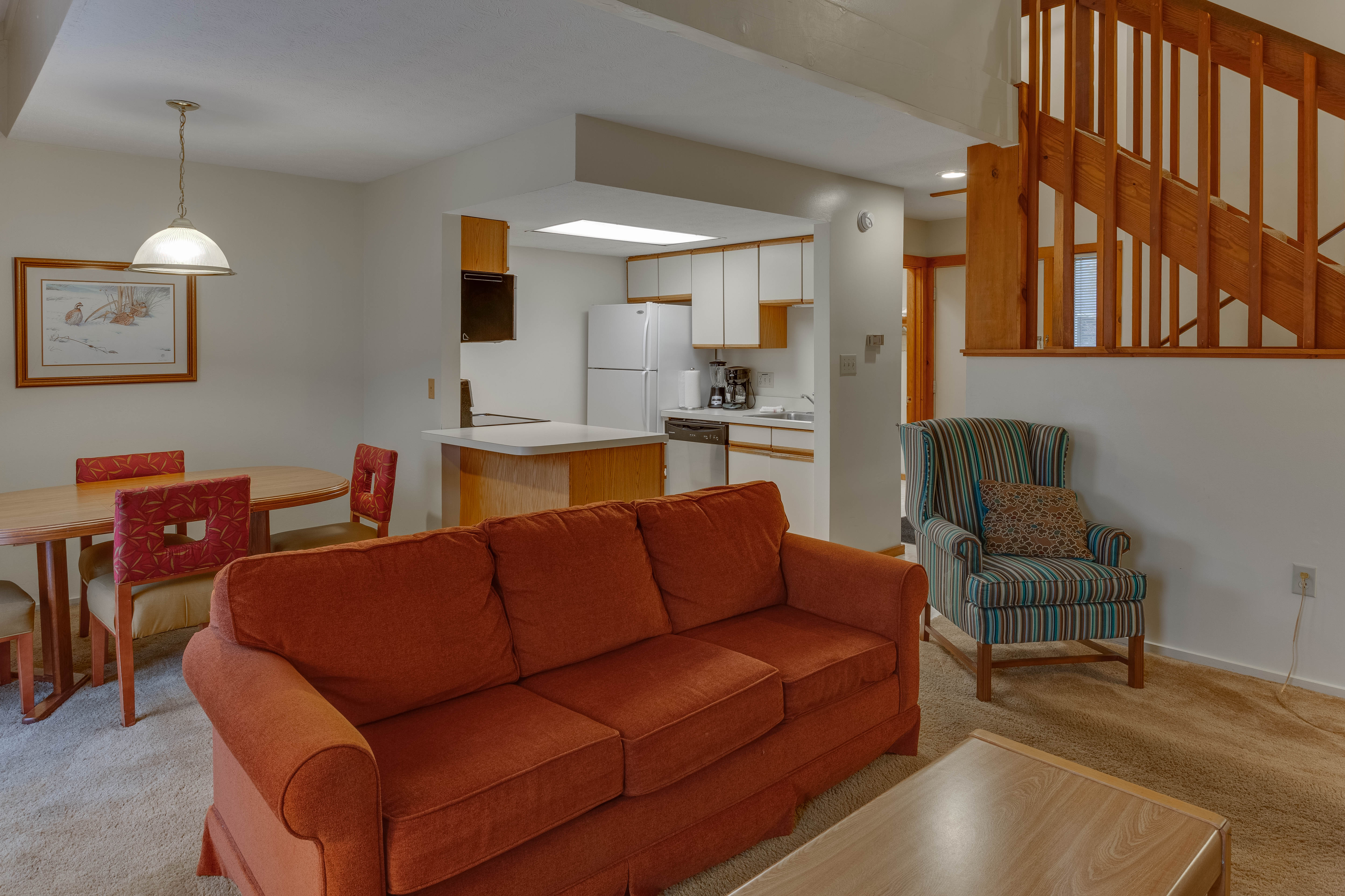 image Open-concept living area with warm wood tones, a fireplace, and comfortable seating—perfect for relaxing after a day outdoors.