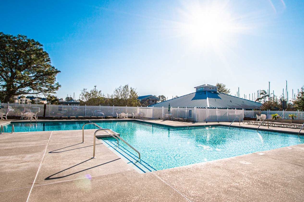 image Dive into family fun at this inviting outdoor pool, set against a radiant blue sky, perfect for relaxing days by the riverside.