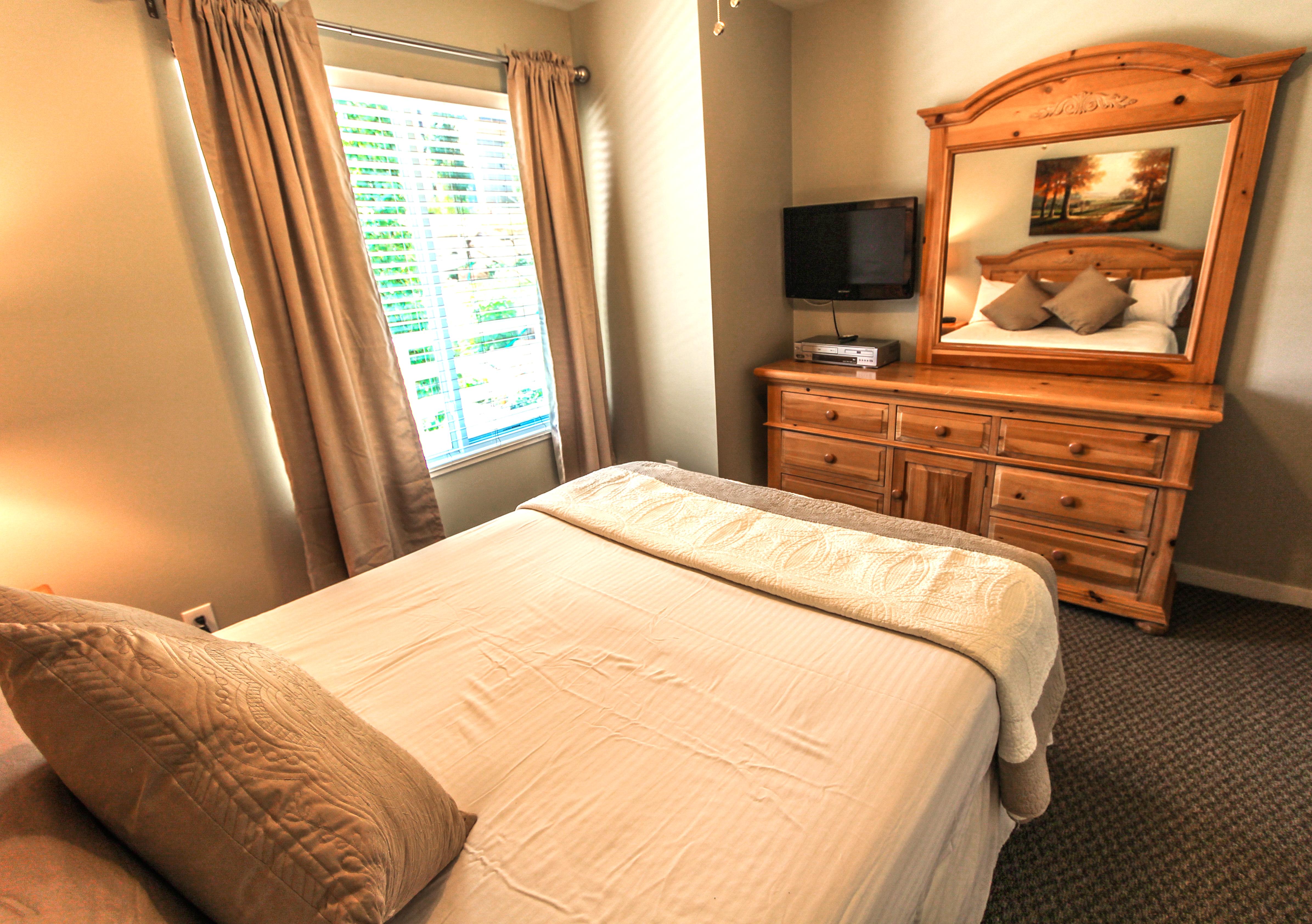 image This inviting queen bedroom boasts warm natural light, a flat-screen TV for entertainment, and stylish furnishings, making it a perfect retreat after a day on the slopes.