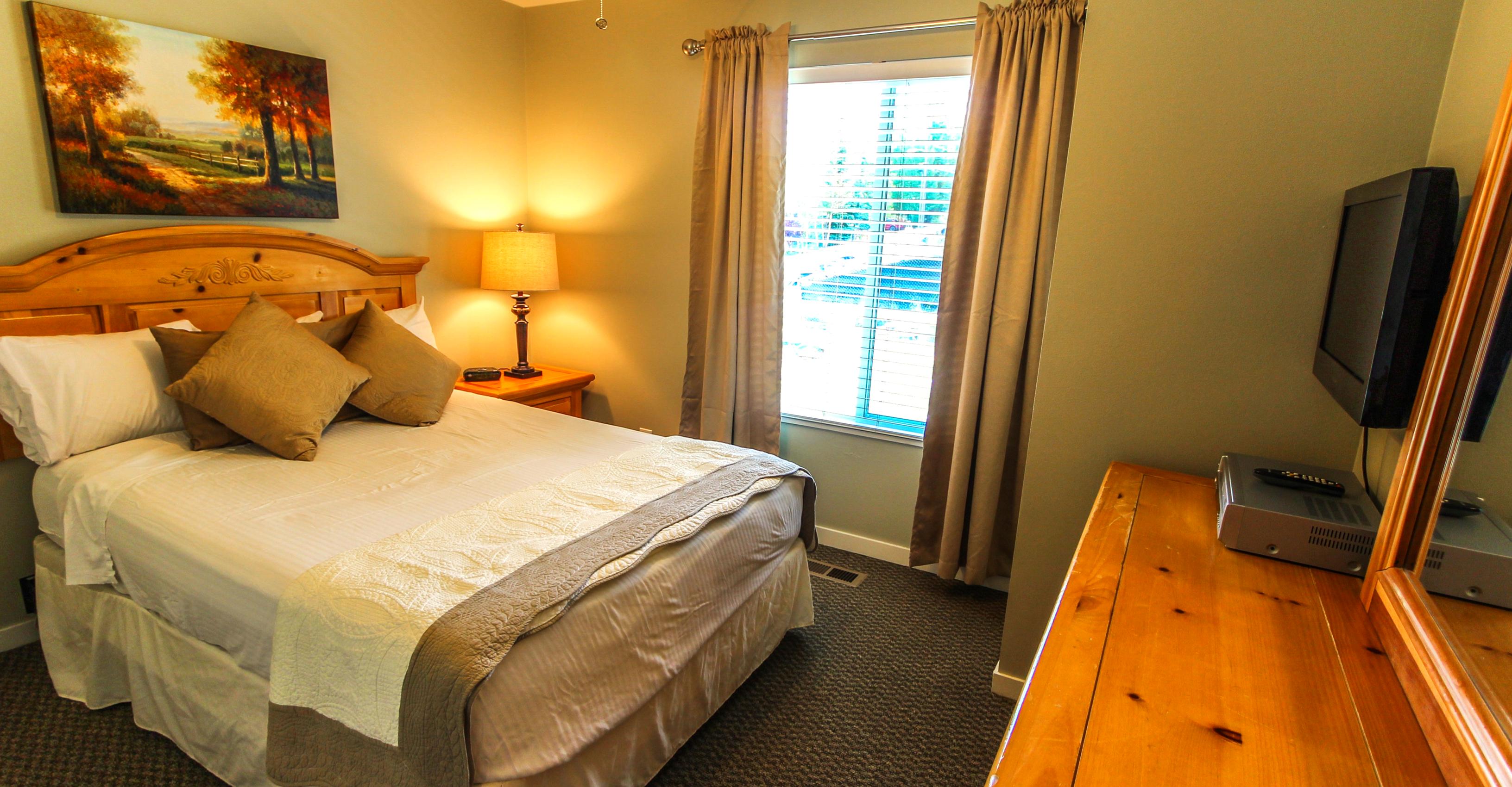 image Relax in this inviting queen bedroom which combines comfort with a mountain aesthetic, ideal for unwinding after a day of adventure.