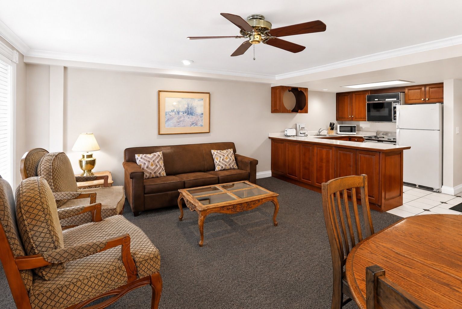 image Living area with couch, artwork, and kitchen view.