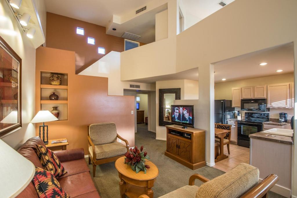 image Experience the seamless flow of this chic two-story villa's living space, where the stylish decor and fireplace enhance the overall ambiance, leading to the inviting kitchen and beyond.