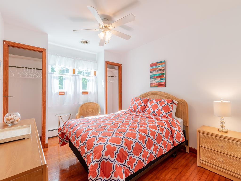 image Relax in this lovely bedroom adorned with vibrant decor, offering a peaceful escape in a tranquil setting with ample closet space.