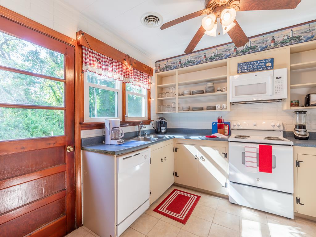 image With sunny windows and a welcoming ambiance, this kitchen invites you to relax and savor every cooking experience, all while keeping an eye on the lush outdoors.