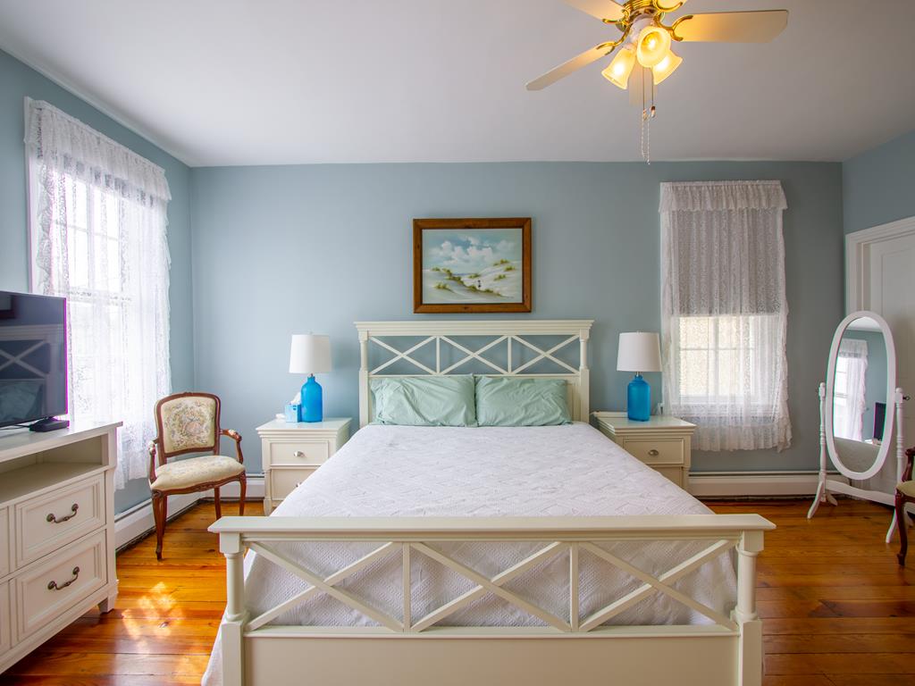 image Experience restful nights in this charming Victorian-style bedroom adorned with beachy decor, ample space, and cozy seating just half a block from the beach in the Historic District.