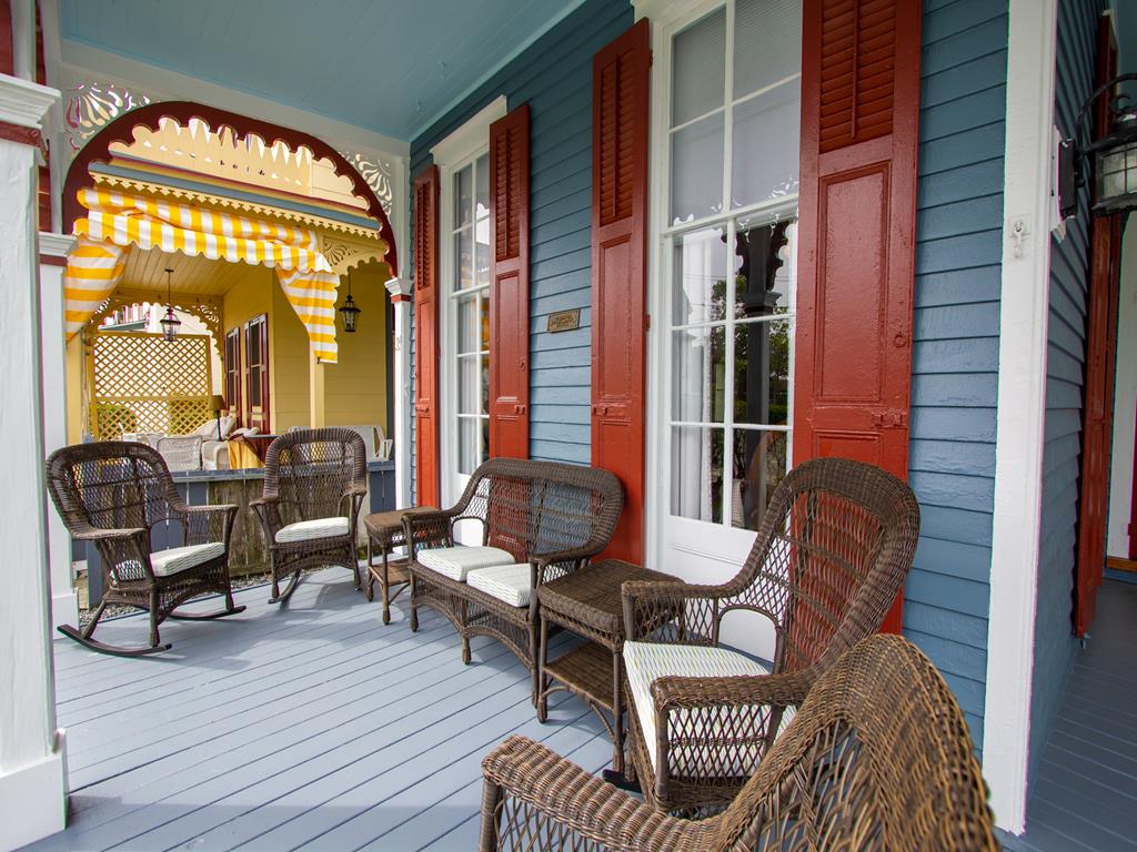 image Enjoy breezy mornings on the porch, where wicker seating invites you to relax in style while soaking up the ambiance of the Historic District.