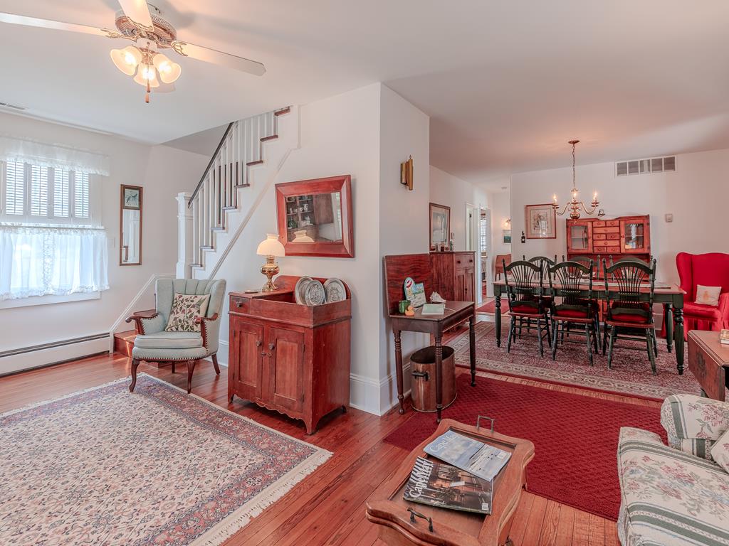 image The inviting dining area, accented by classic furniture and a charming chandelier, is perfect for family meals, while the adjoining spaces offer a seamless flow throughout this delightful coastal home.