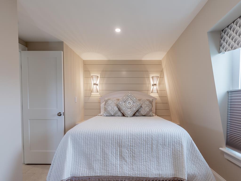 image Retreat to this serene queen bed sanctuary adorned with soft lighting and inviting textures, offering a cozy ambiance for restful nights after a day by the shore.