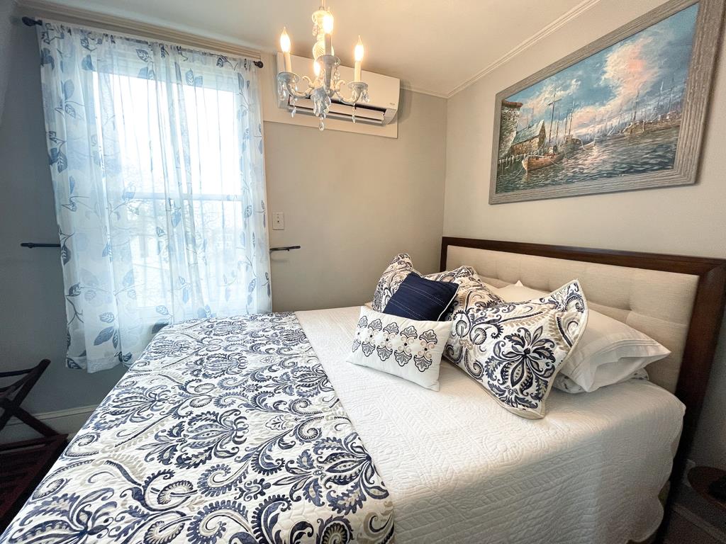 image Retreat to this beautifully decorated bedroom complete with a chic chandelier and cozy decor, ensuring a peaceful night's sleep.
