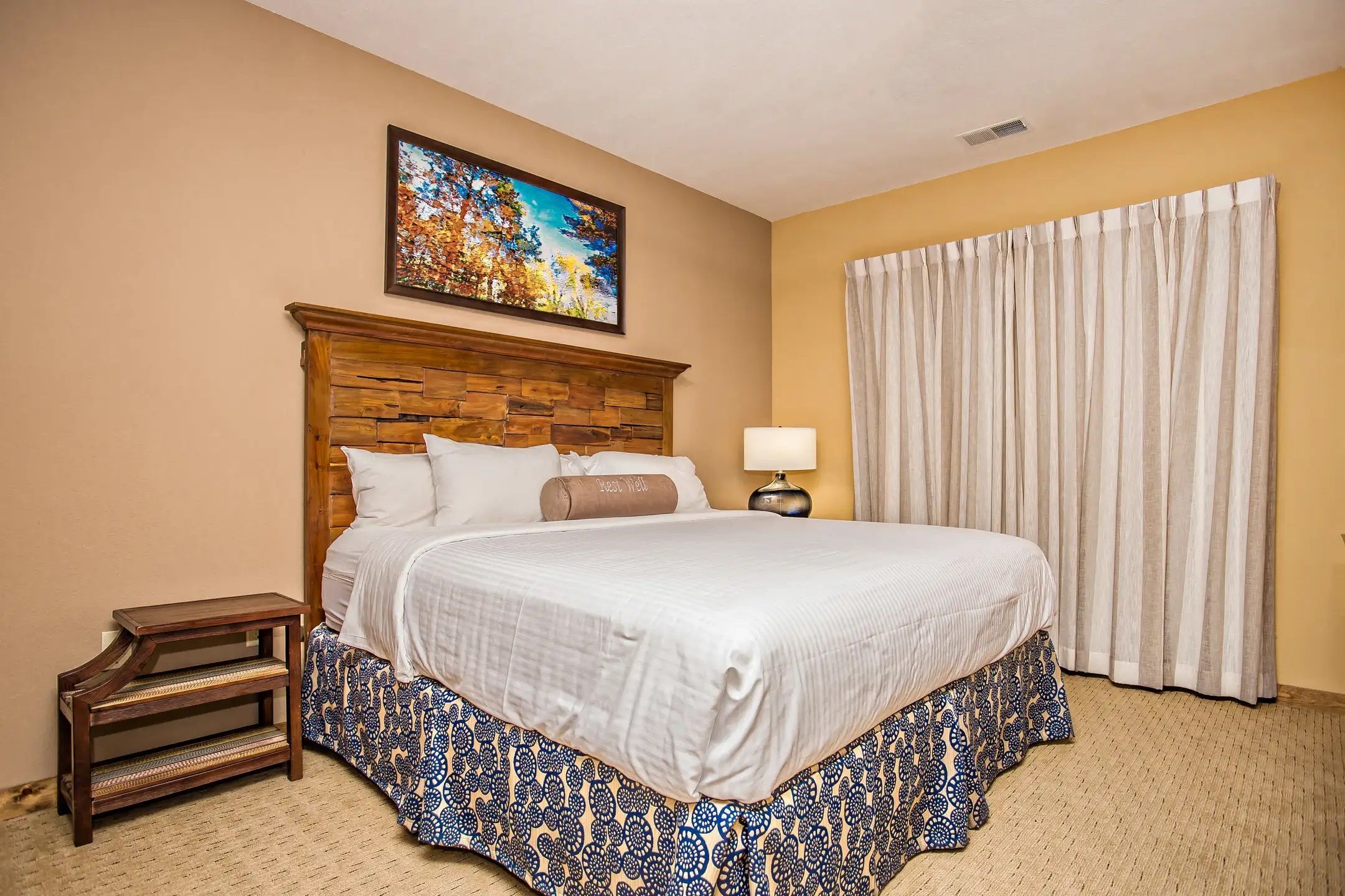 image Retreat to the cozy bedroom furnished with a plush king-sized bed, ample natural light, and charming decor for a restful night’s sleep.