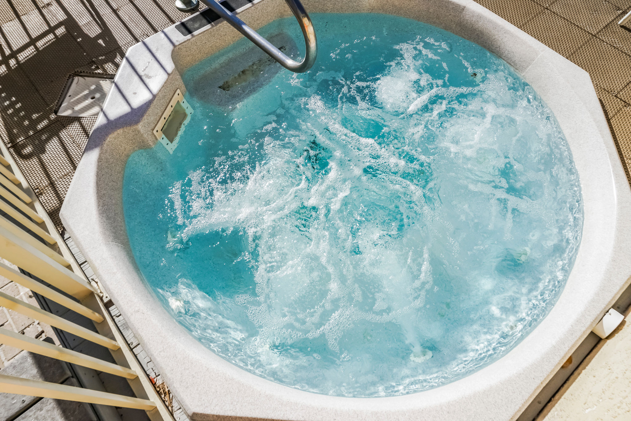 image Relax in the bubbly hot tub, positioned for ultimate relaxation, where guests can unwind while soaking in the sun and enjoying the coastal atmosphere.