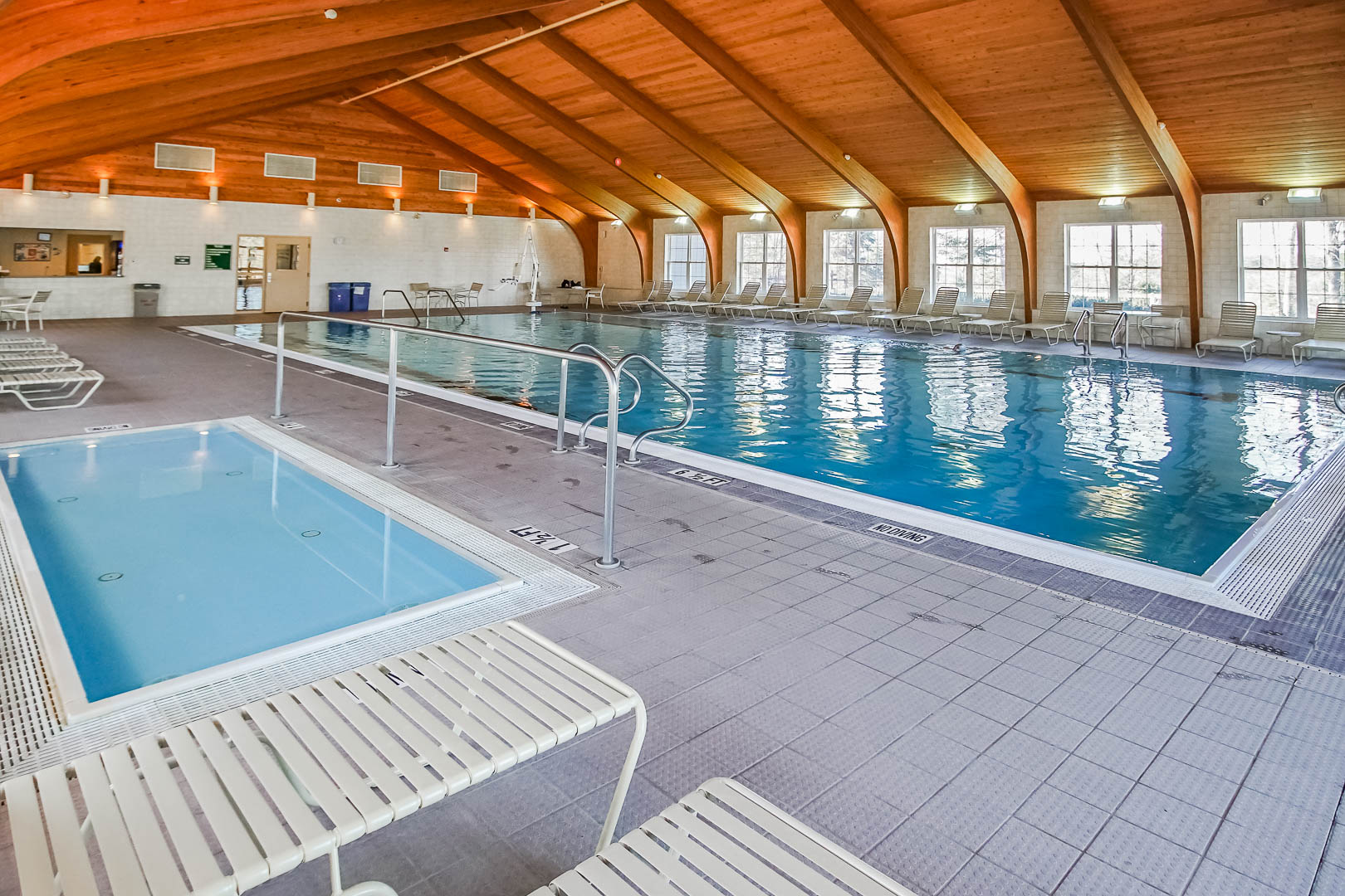 image Immerse yourself in tranquility at the indoor pool area, complete with a hot tub and ample seating for relaxing after a day exploring nearby golf courses.