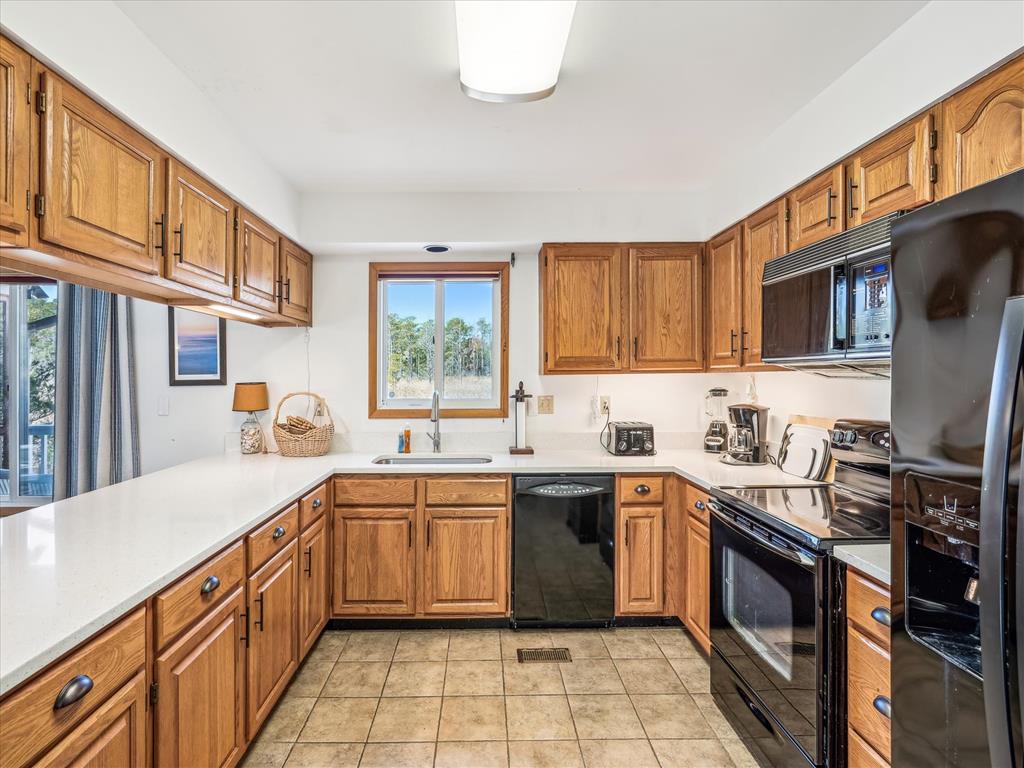 image The well-equipped kitchen boasts wooden cabinetry and modern appliances, providing a functional space for family meals and gatherings while overlooking the lush outside scenery.