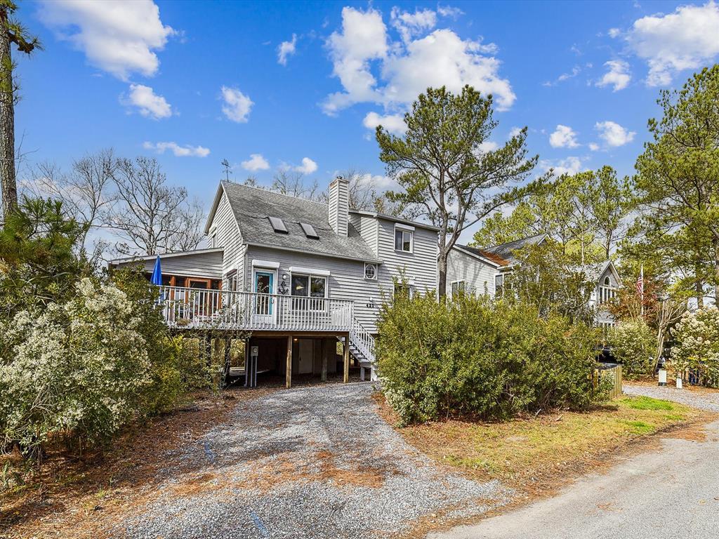 image The exterior of the vacation home showcases a charming facade with ample parking space, inviting you to experience the comfort and convenience it has to offer.