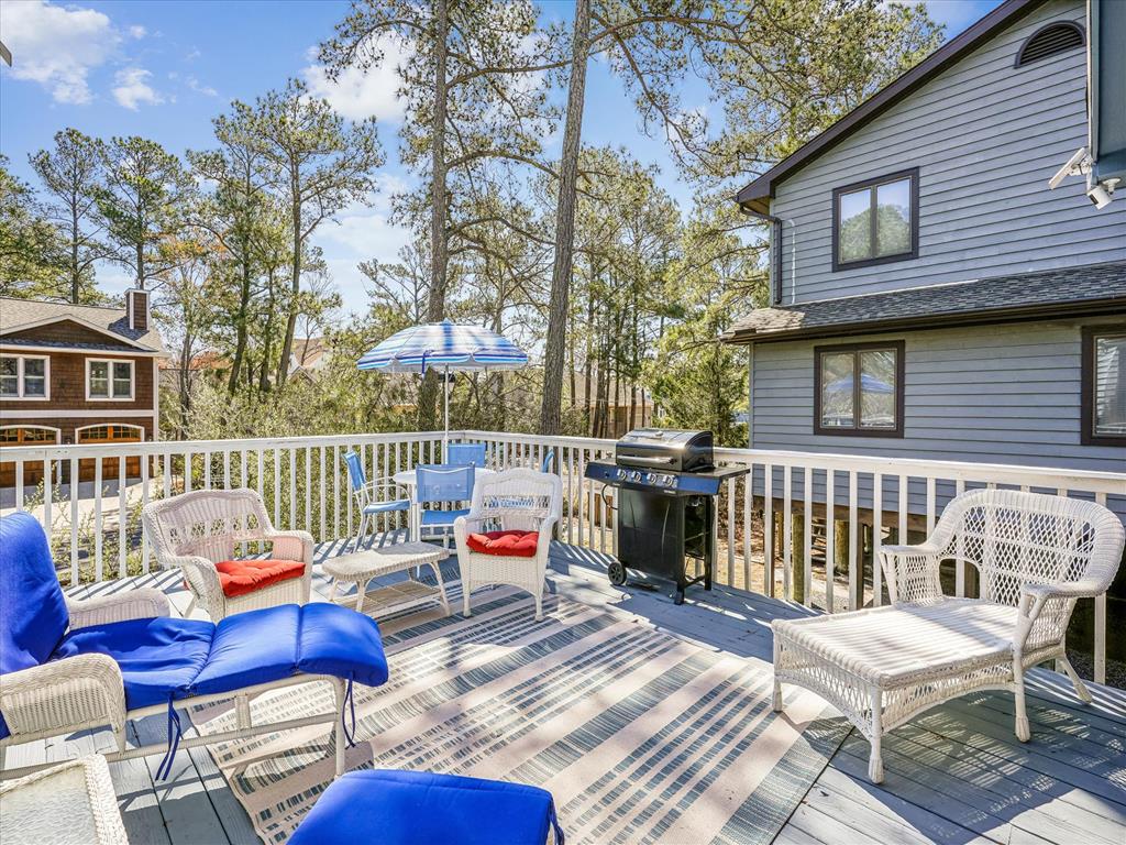 image Step out onto the spacious deck, equipped with lounge chairs and a BBQ grill, where you can enjoy serene views of the surrounding wetlands under a bright blue sky.