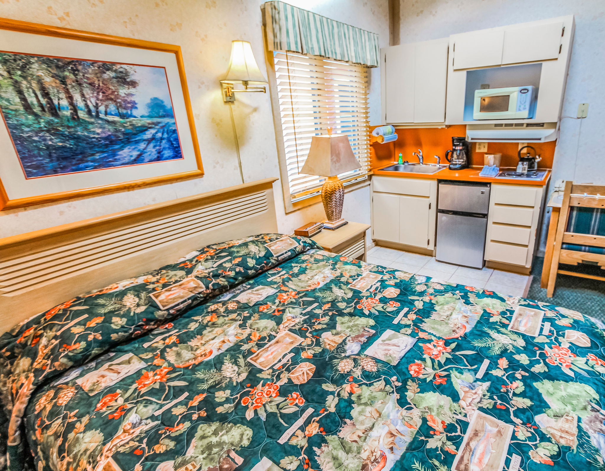 image This well-lit studio offers a queen bed, armchair, and a convenient kitchenette, ideal for a comfortable stay.