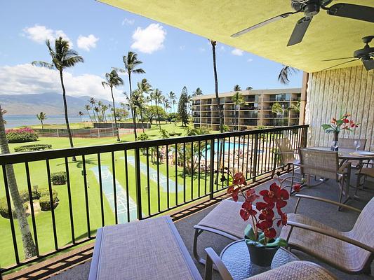 image Enjoy stunning ocean views and tropical palm trees from the spacious balcony, complete with comfortable seating for relaxation.