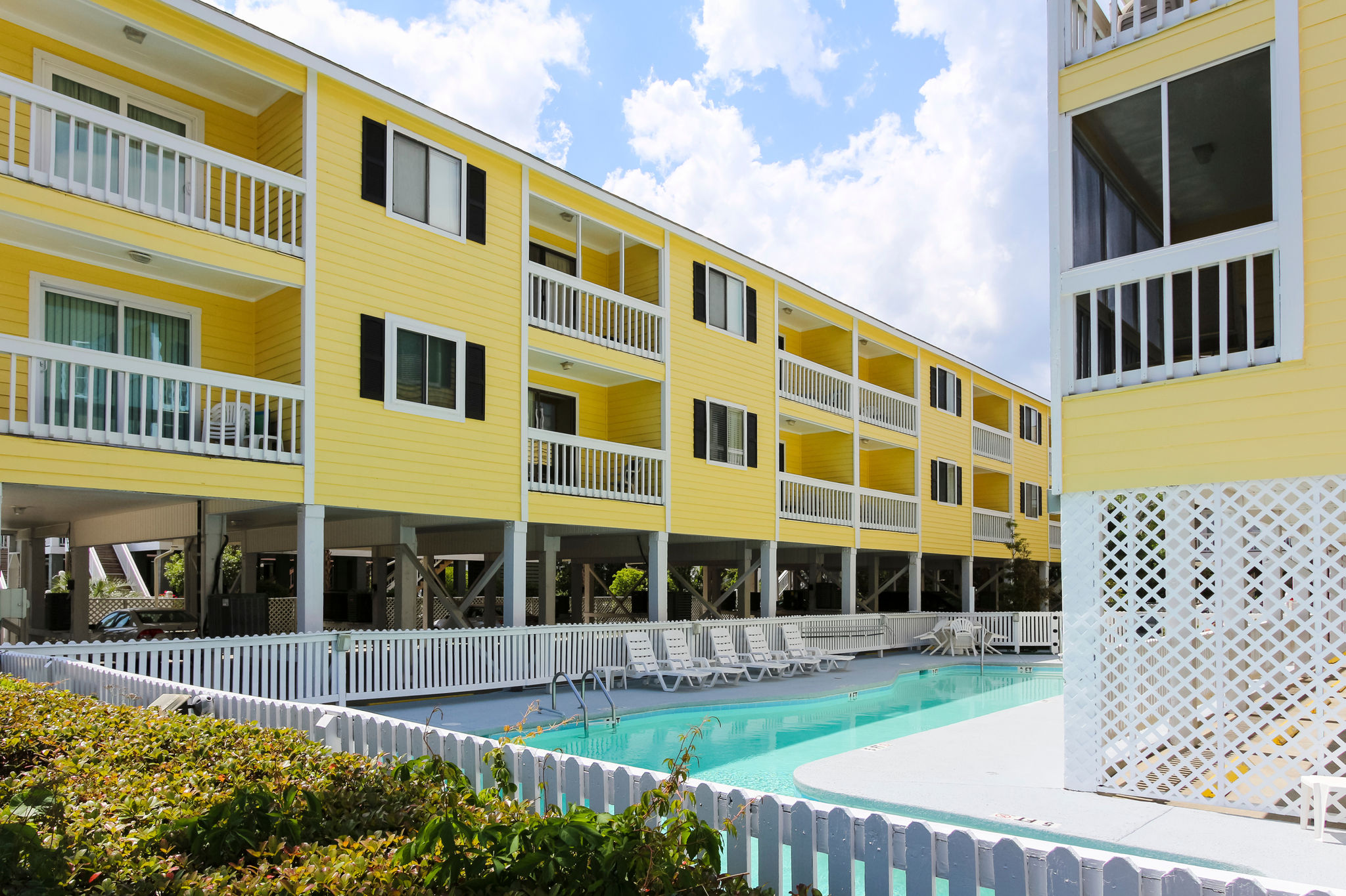 image Experience resort-style living at Sandy Shores III with its inviting outdoor pool and well-maintained grounds, perfect for unwinding after a day at the beach.