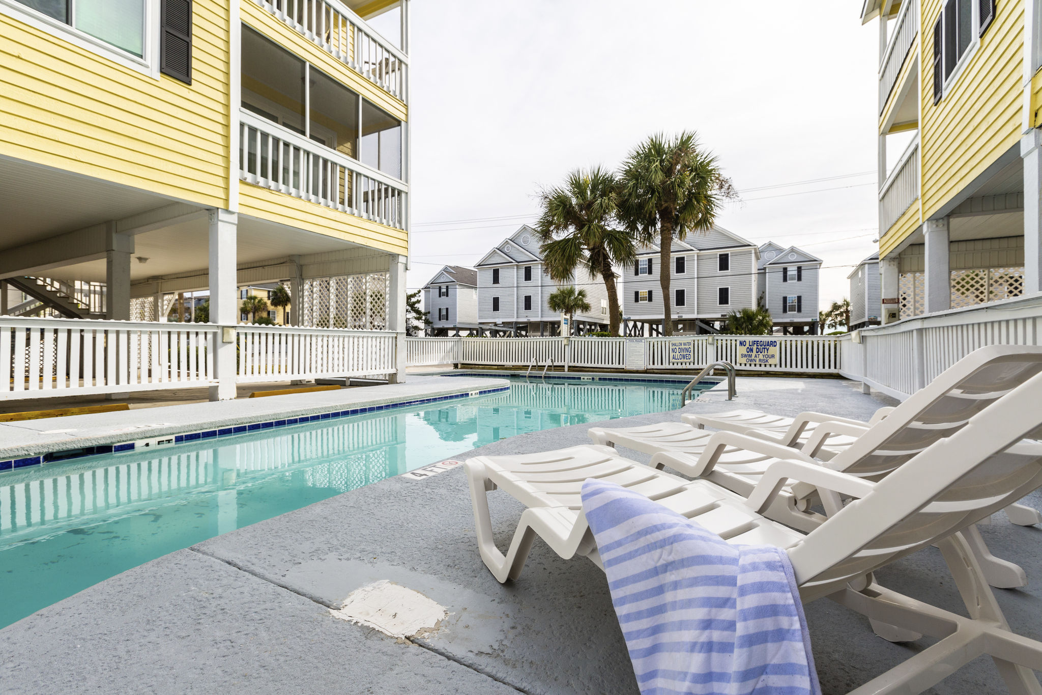 image Enjoy sunny days by the shimmering outdoor pool at Sandy Shores III, right across the street from the beautiful beach.