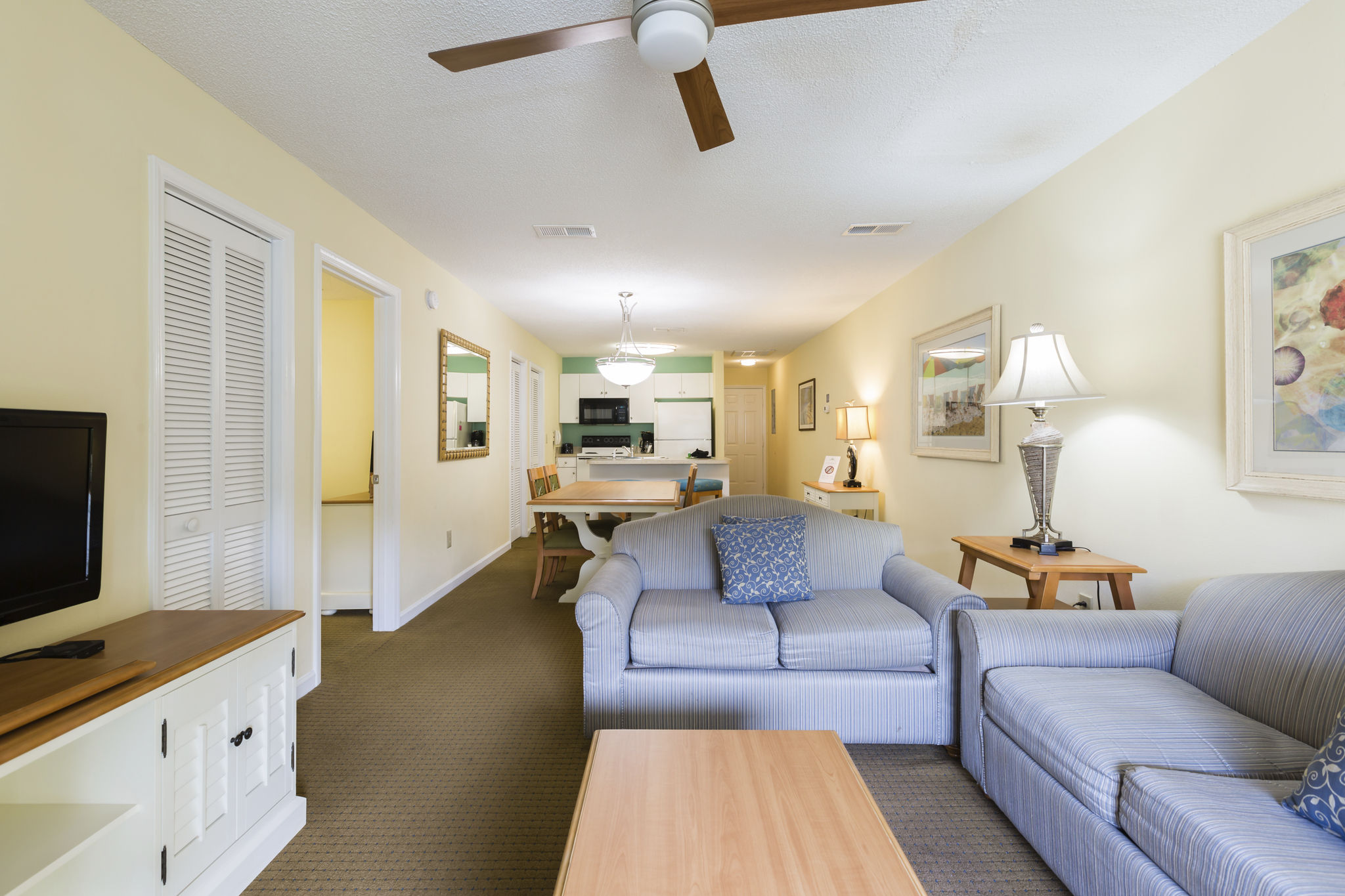 image Enjoy the open-concept living area with comfortable seating, a flat-screen TV, and easy access to the dining area and full kitchen.