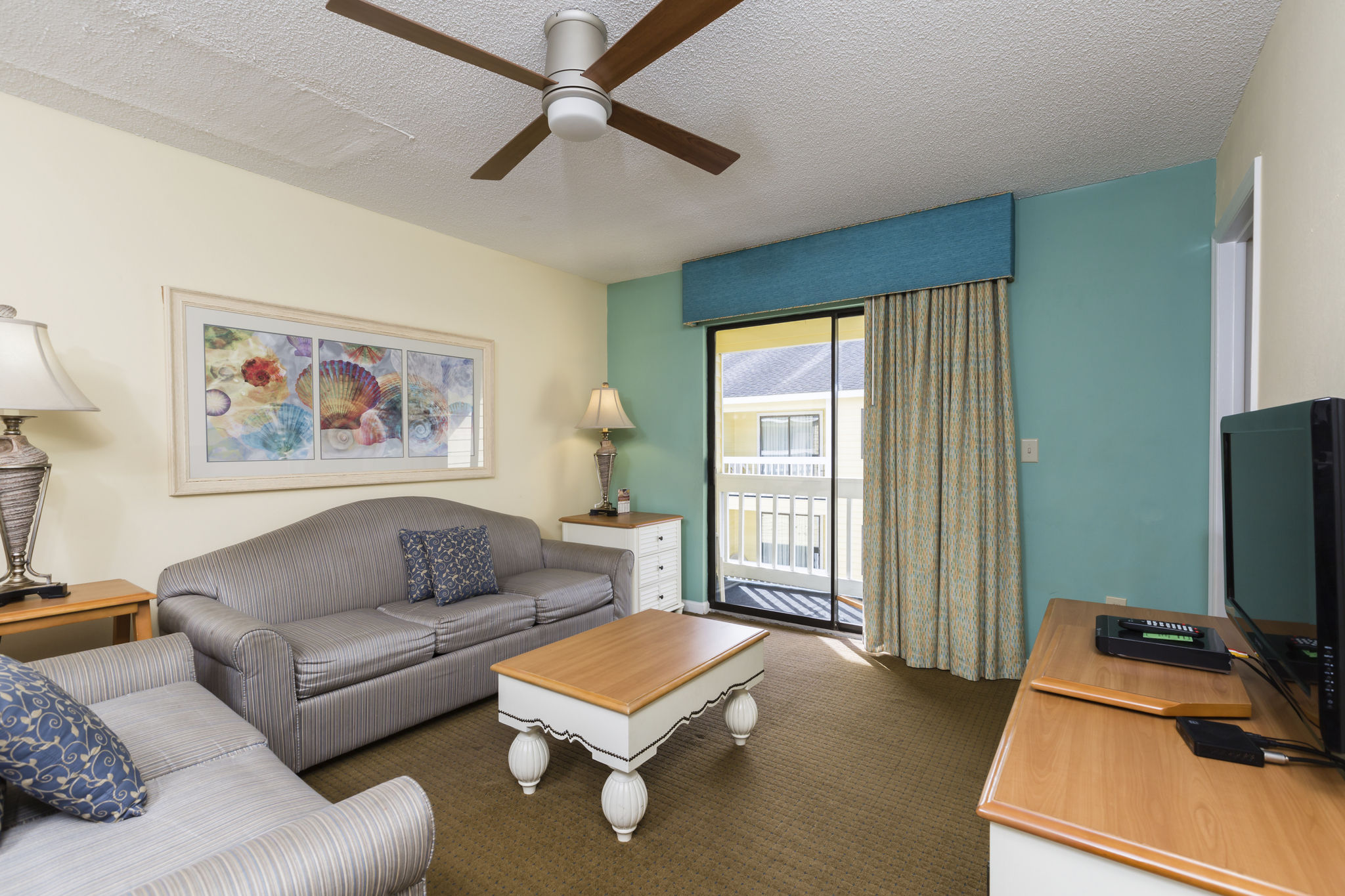 image Bright and airy living room with sliding doors that lead to a private balcony, perfect for savoring warm coastal breezes.