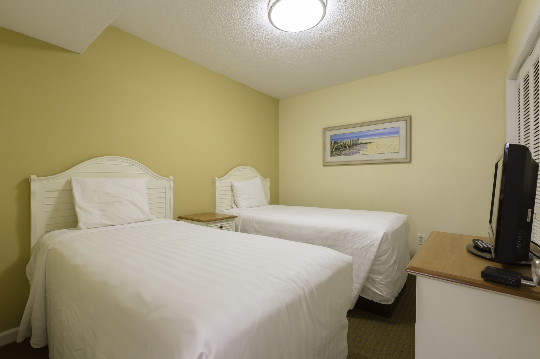 image The inviting guest room with twin beds offers comfortable accommodations for families or friends traveling together.