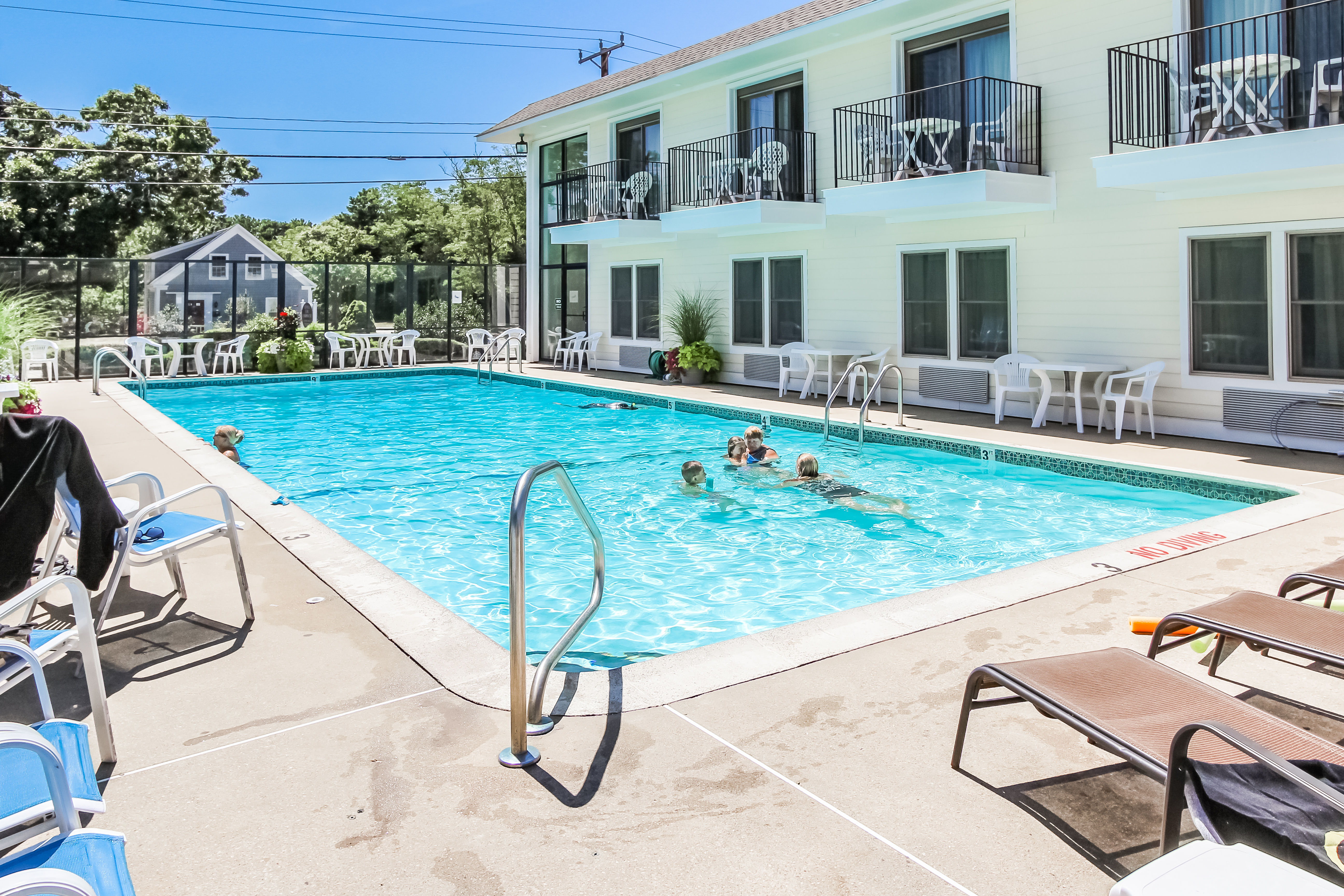 image Families relax in the spacious outdoor pool area, complete with lounge chairs and sunny skies, ideal for quality time.