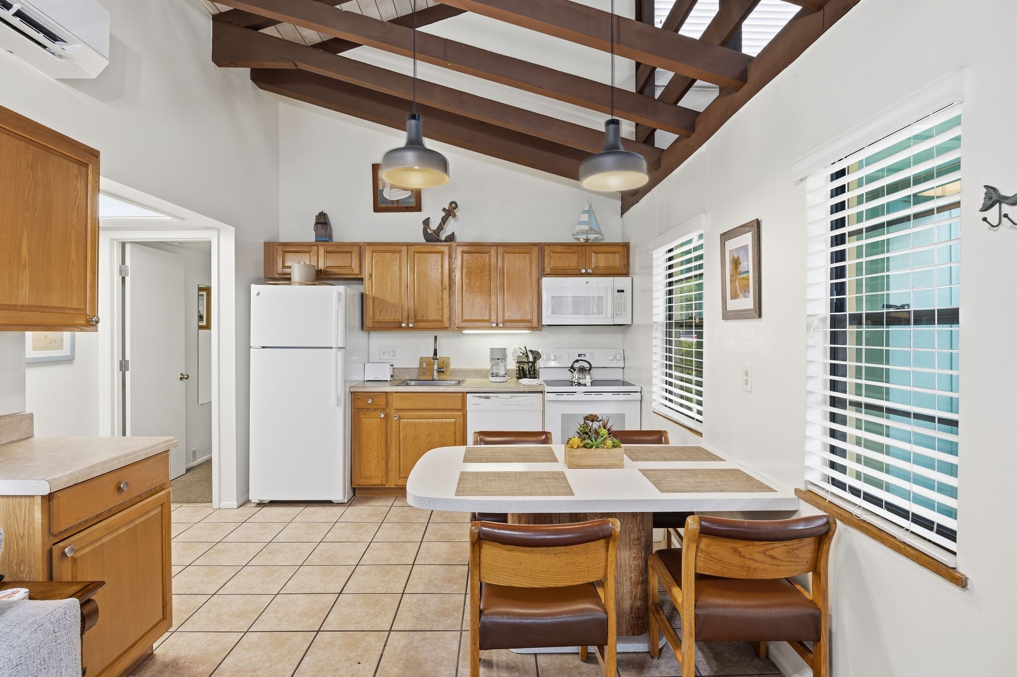 image The open kitchen includes wood cabinetry, modern appliances, and a dining table with seating for shared meals.