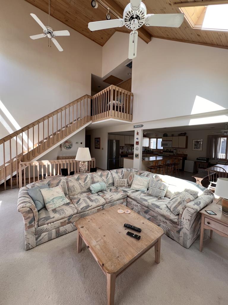 image An airy open-concept living space showcasing a cozy sofa arrangement and a staircase leading to an upper level.