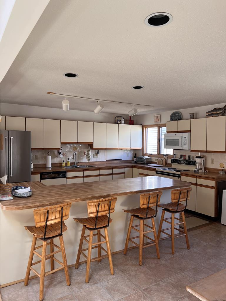 image A fully equipped kitchen with modern appliances and a breakfast bar, ideal for preparing meals and entertaining.