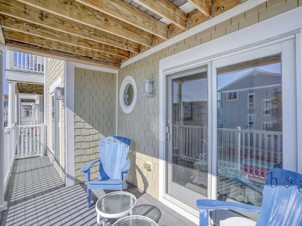 image The lovely outdoor deck area is adorned with cozy seating and beach-themed decor, ideal for enjoying morning coffee or sunset views while breathing in the fresh sea breeze.