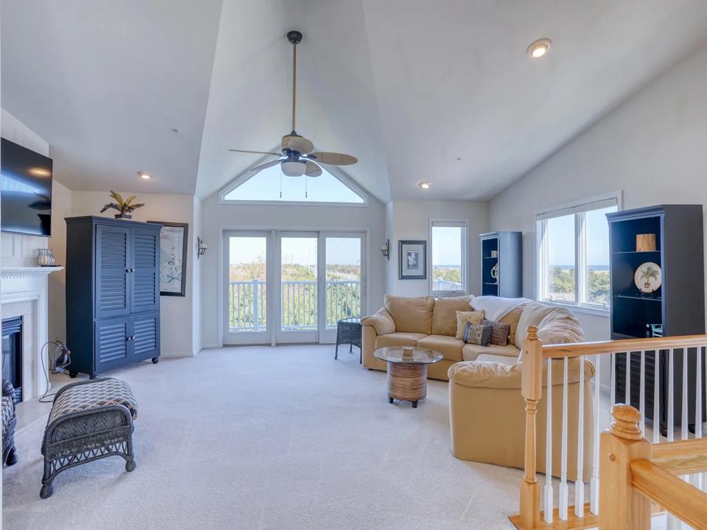 image The spacious living room boasts vaulted ceilings, plush carpet, and expansive windows that frame breathtaking ocean views, creating a perfect spot for relaxation and social gatherings.