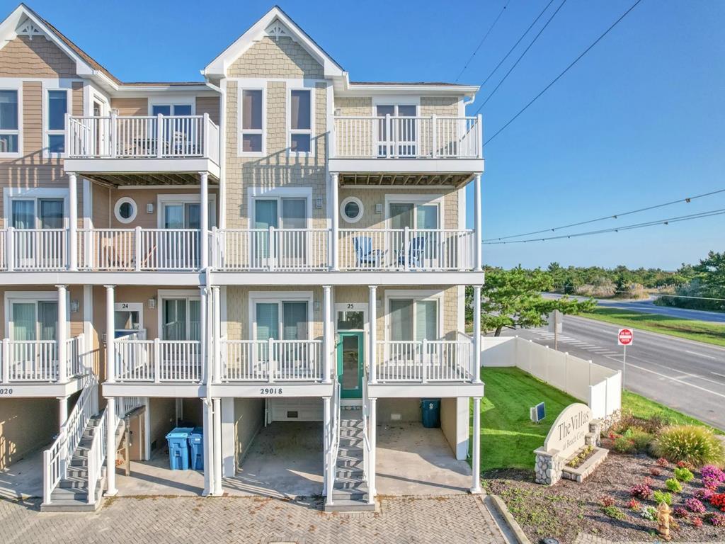 image The exterior of this stunning beachfront townhouse showcases a charming facade with multiple private balconies, providing easy access to the sunny coastal lifestyle just steps from the beach.