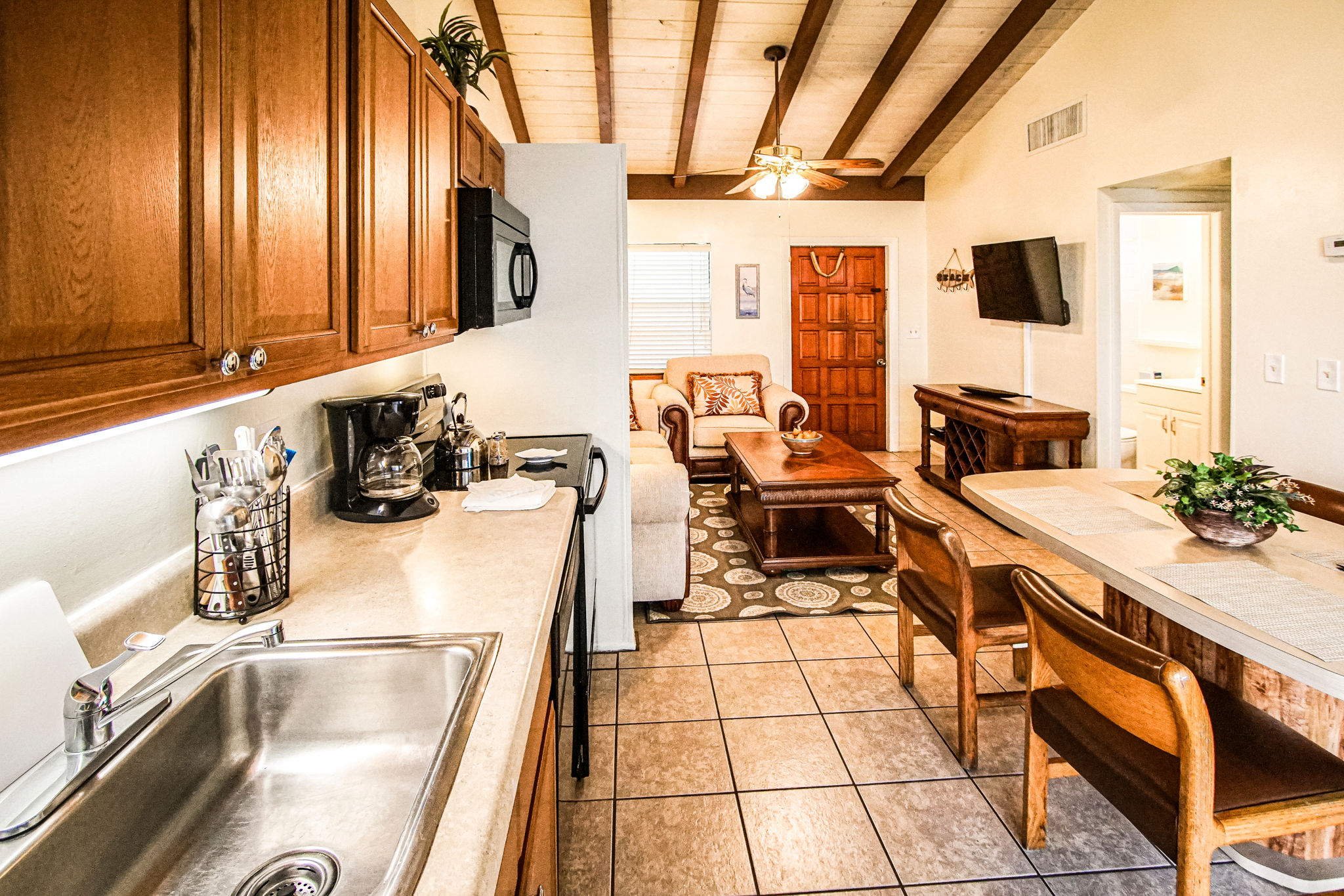 image Enjoy home-cooked meals in the full kitchen of your beachfront retreat, complete with spacious dining and living areas featuring a Smart TV.