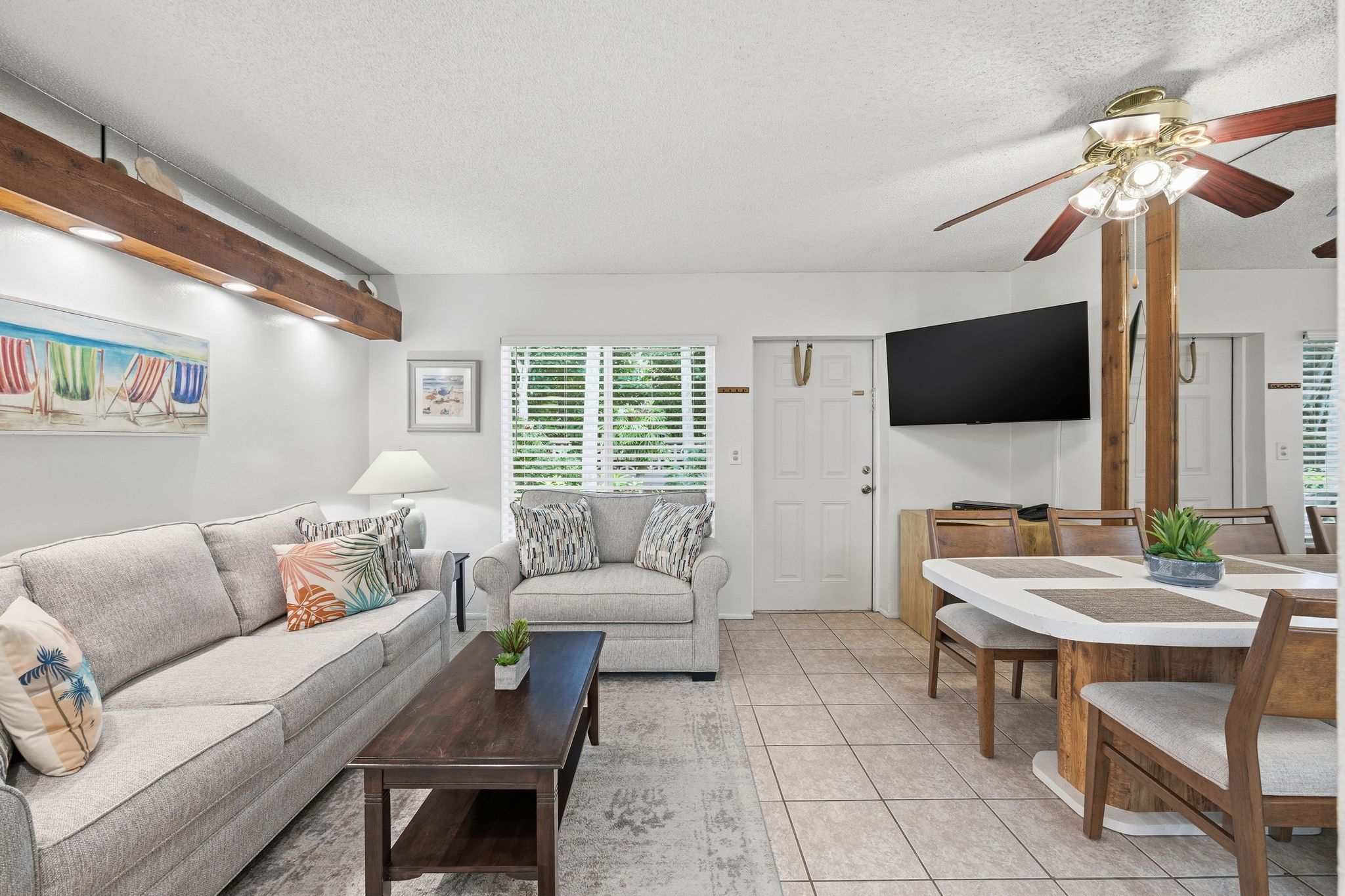 image The living area offers comfortable seating, a coffee table, and a wall-mounted TV, with natural light creating a relaxed oceanview ambiance.