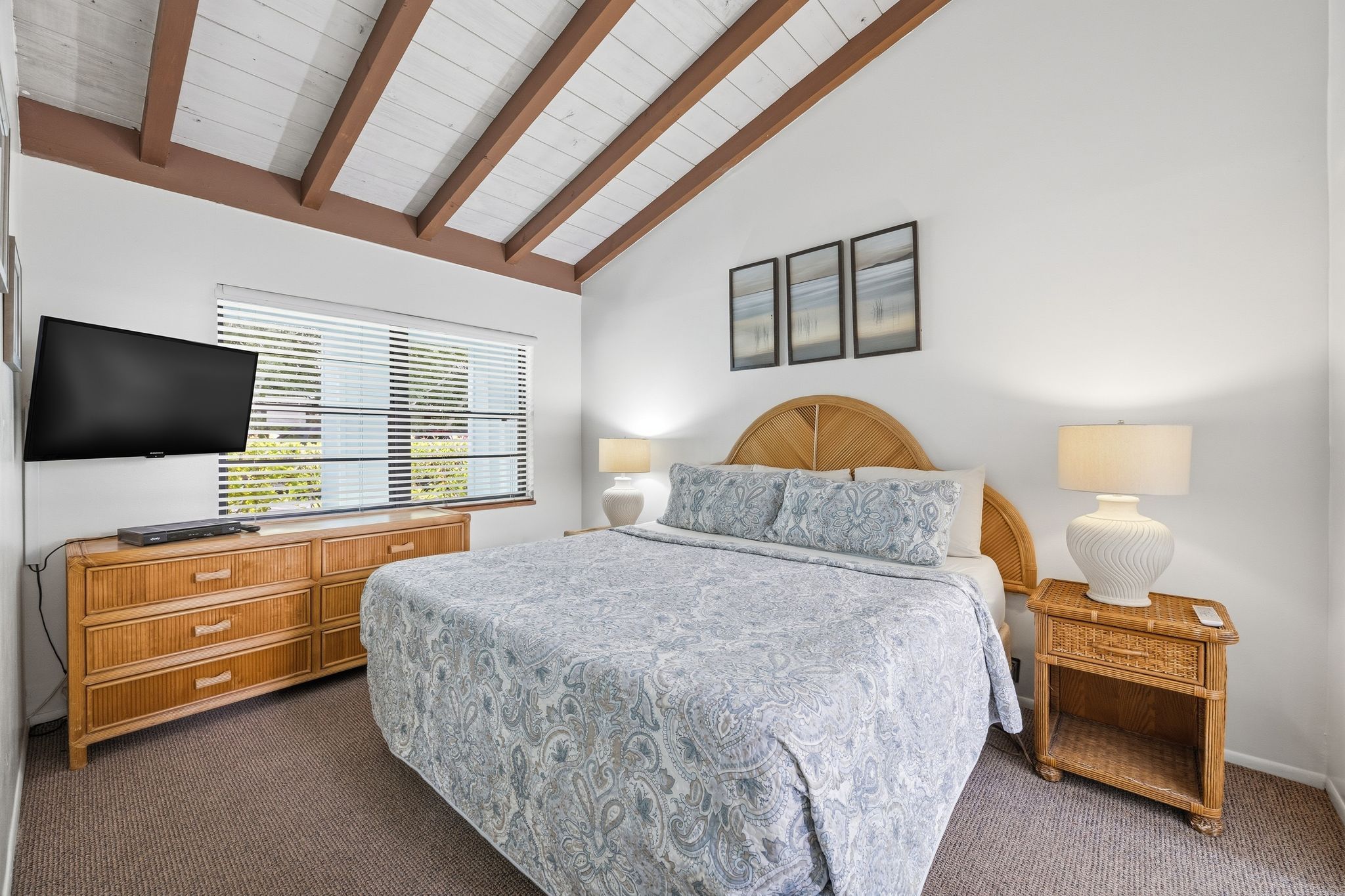 image A comfortable bedroom features a spacious bed, matching furniture, and a wall-mounted TV for added comfort.