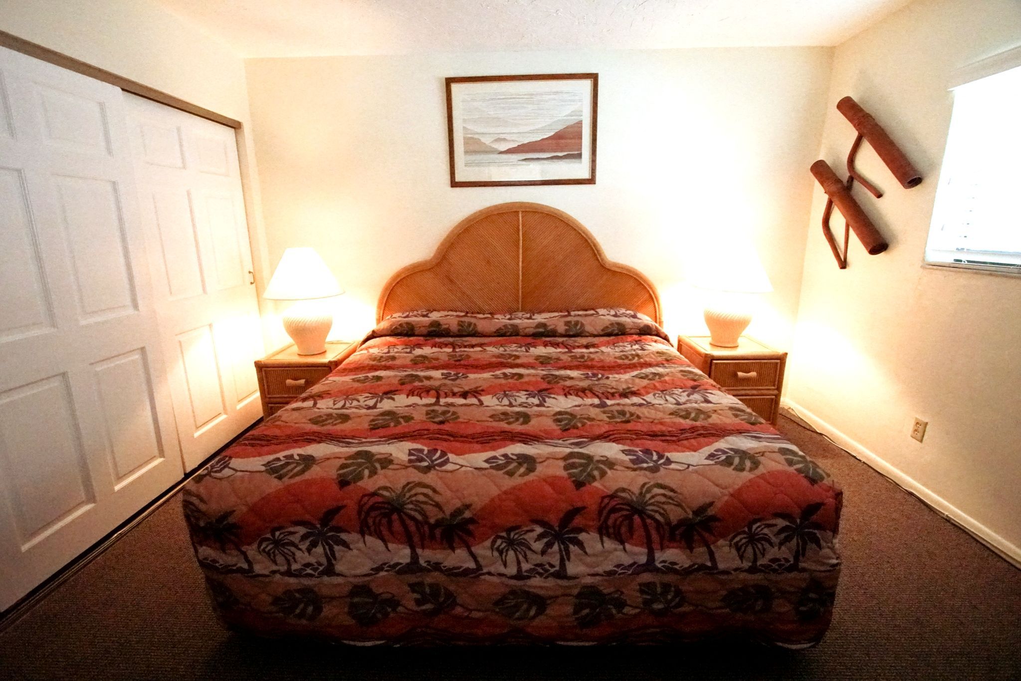image Retreat to this cozy bedroom featuring a comfortable bed and tropical decor, perfect for a restful getaway.
