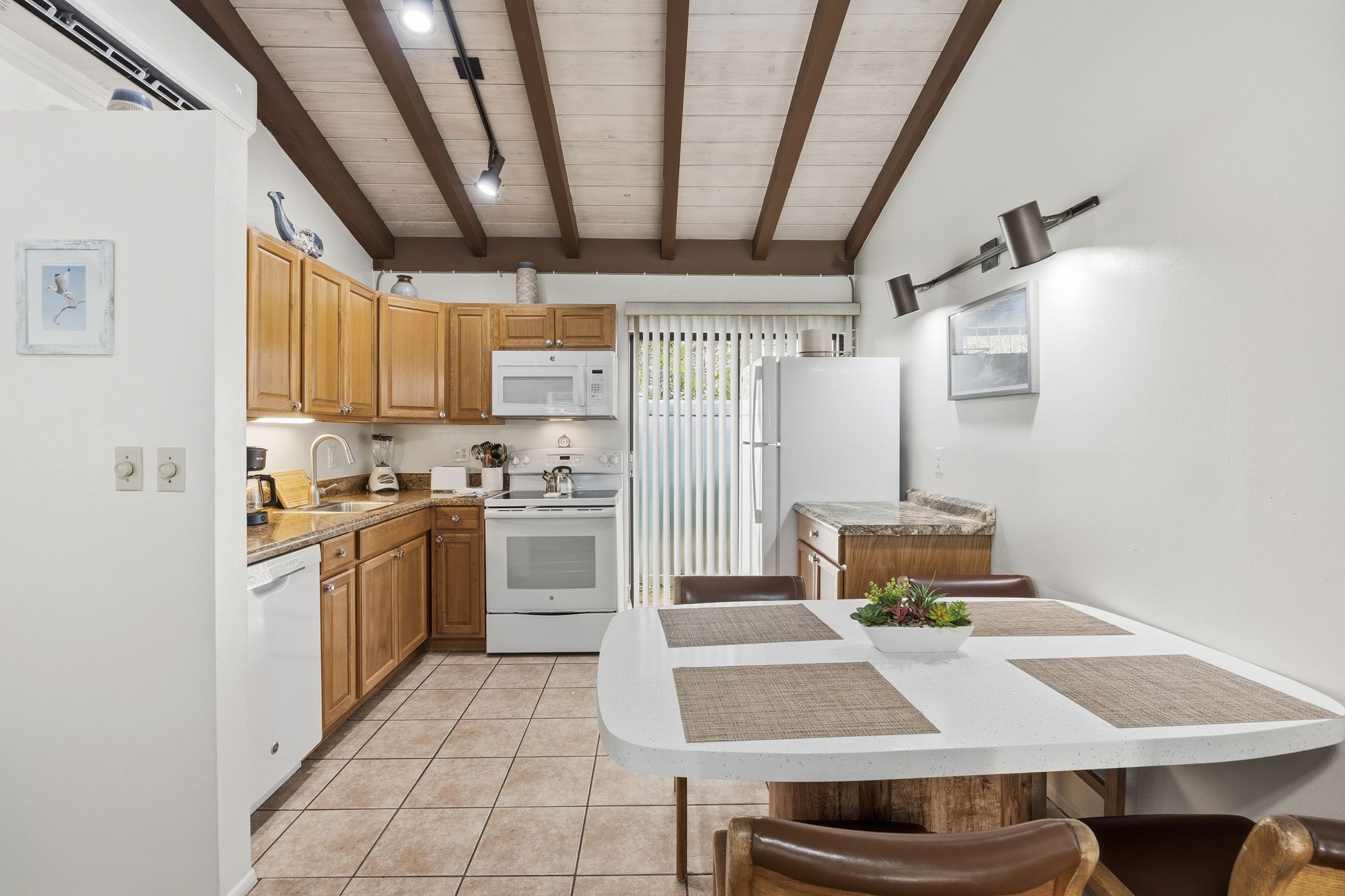 image The dining area includes a round table with seating, conveniently located beside the fully equipped kitchen.