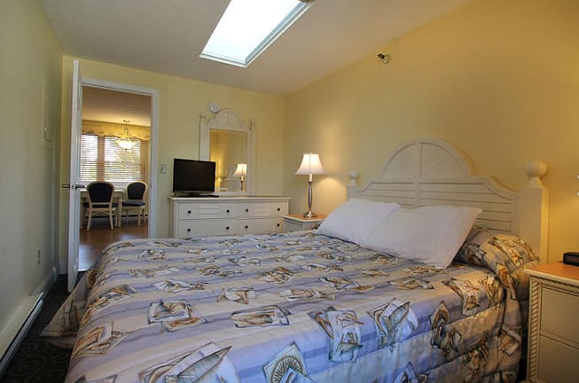 image Relax in this spacious king bedroom featuring soft lighting, a sleek modern bed, and cozy ambiance.