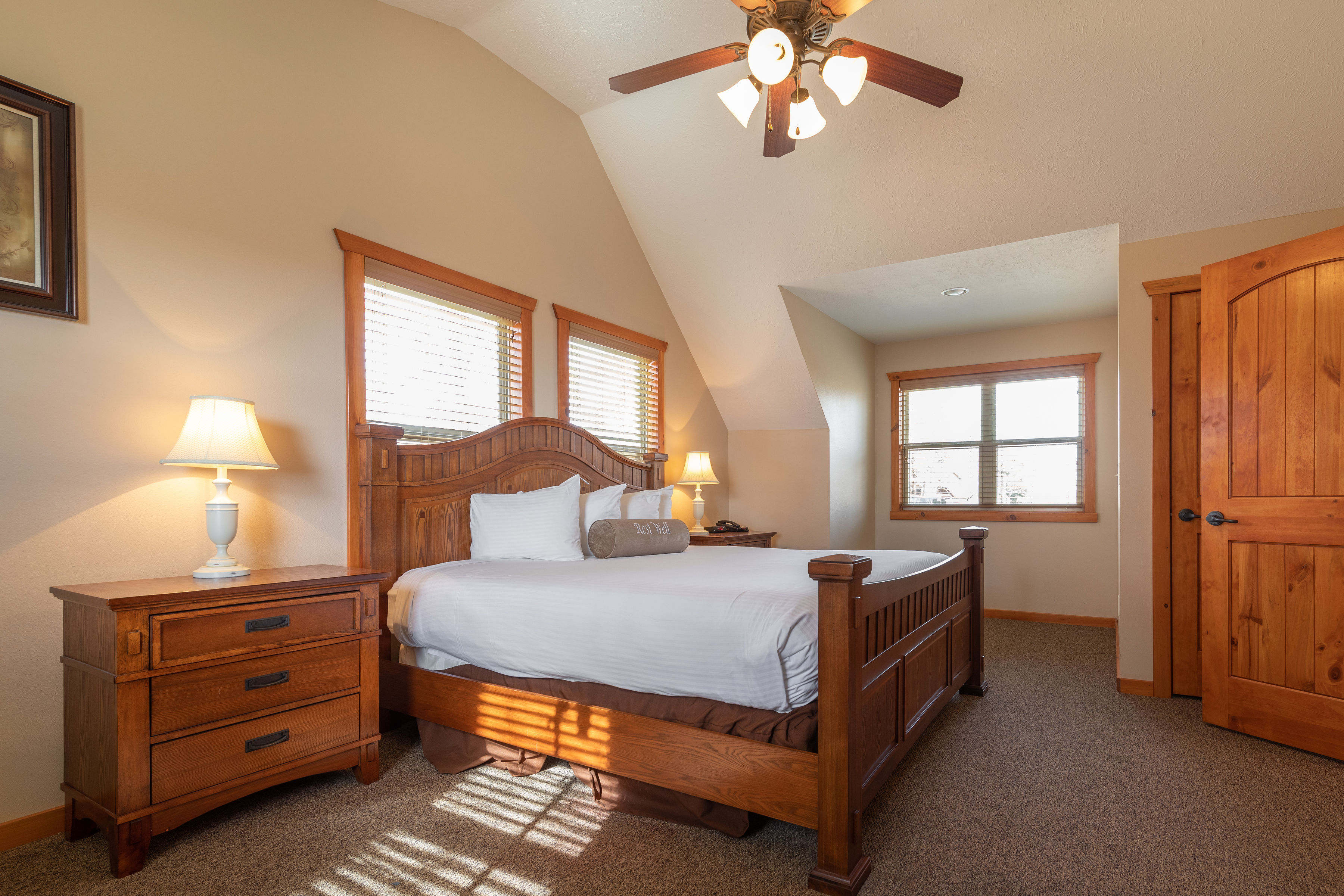 image Unwind in another inviting king bedroom that offers the same warm, rustic charm and natural light, ensuring restful nights for every guest.