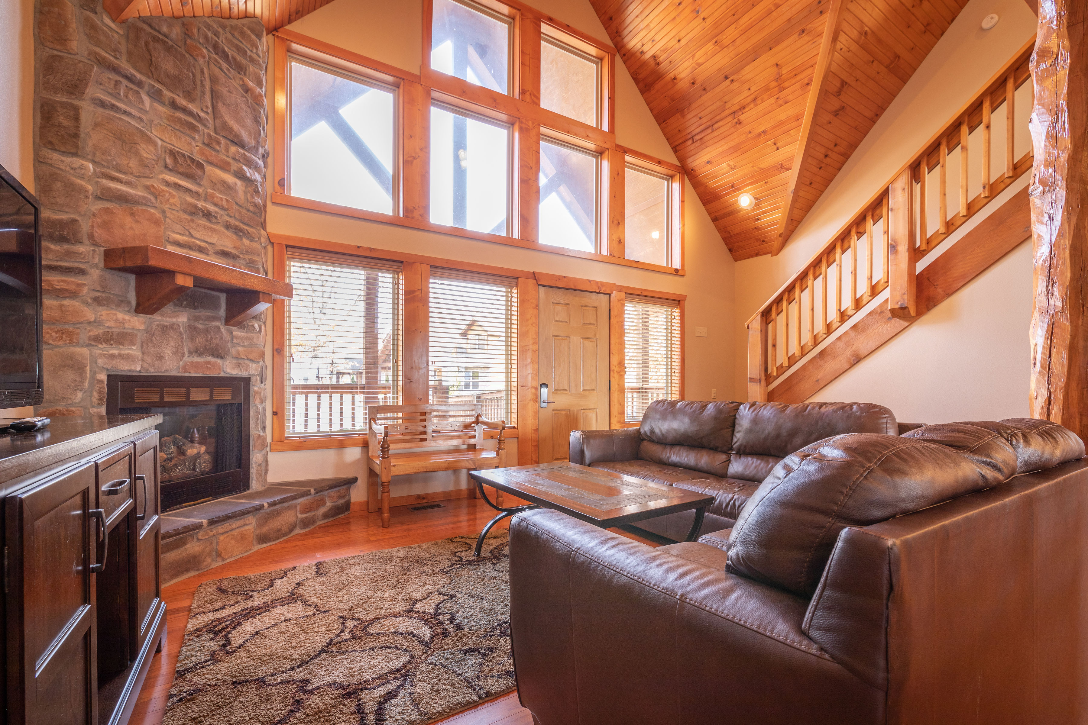 image Unwind in the cozy living room, where natural light floods the space, and a stone fireplace beckons for evenings of relaxation and entertainment.