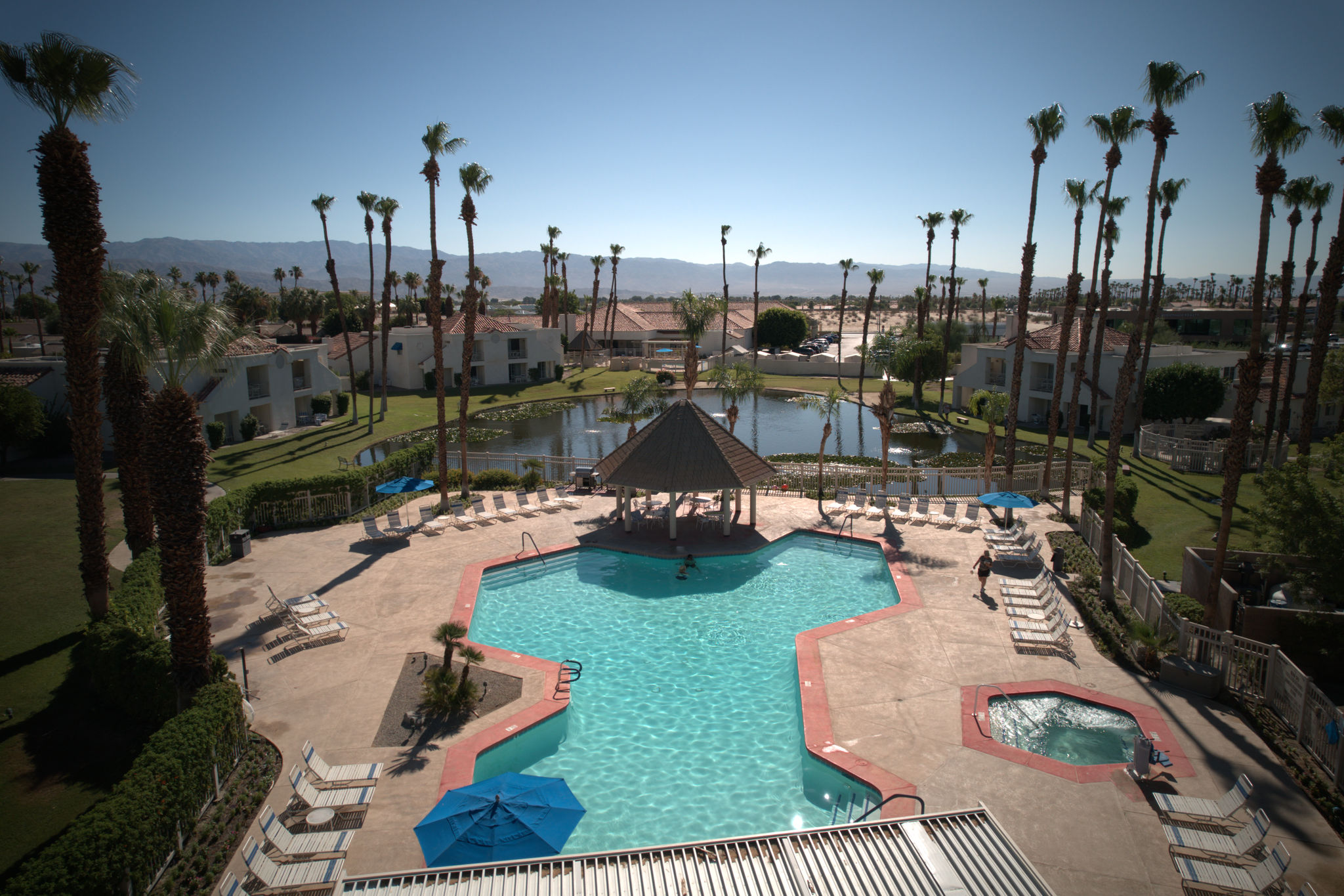 image Take a refreshing dip in the shared pool or soak in the hot tub, all while enjoying the breathtaking scenery of palm trees and mountains at your doorstep.