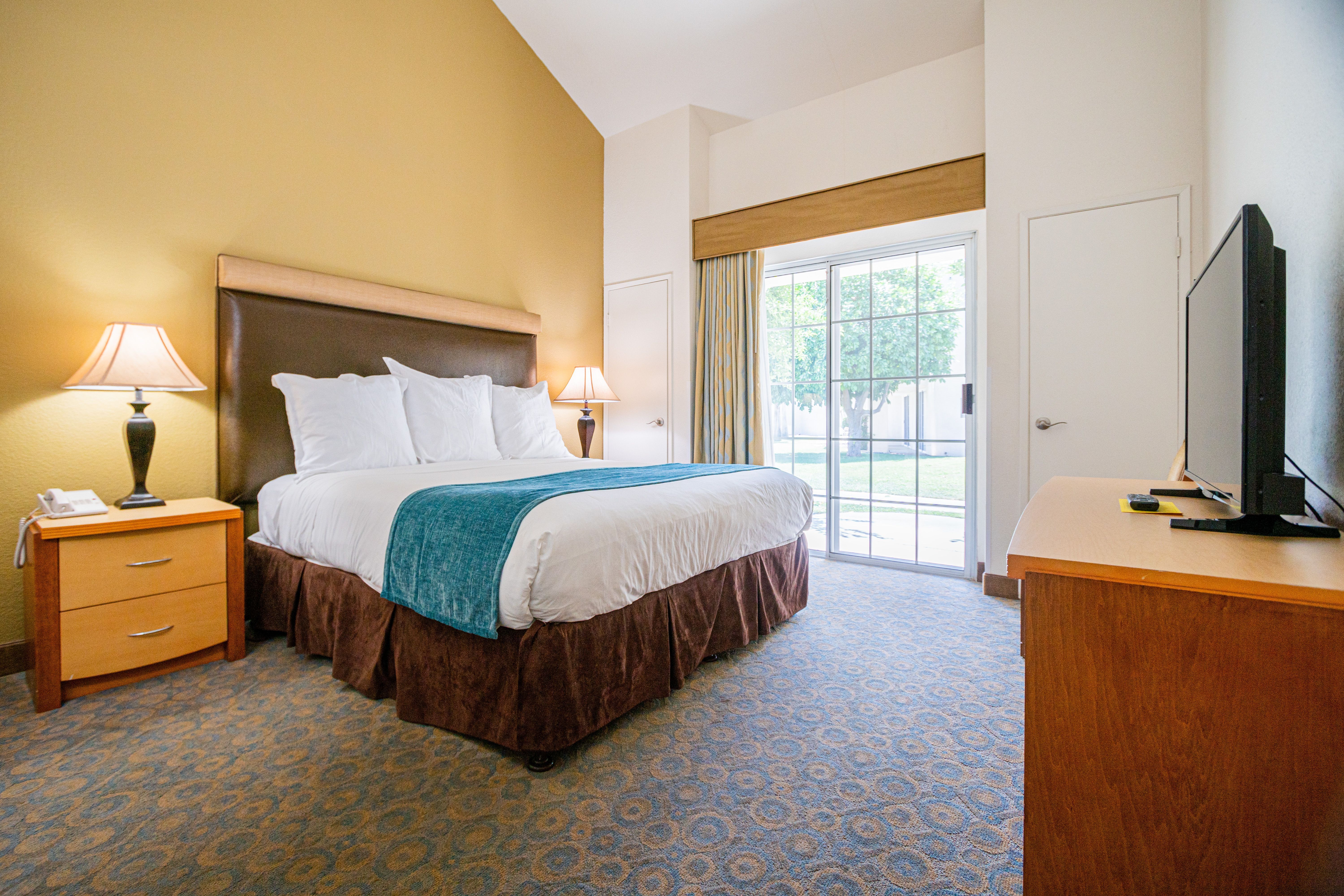 image A spacious bedroom provides a restful haven with ample natural light, plush bedding, and a serene view of the outdoor landscape, ensuring a peaceful night's sleep for all guests.